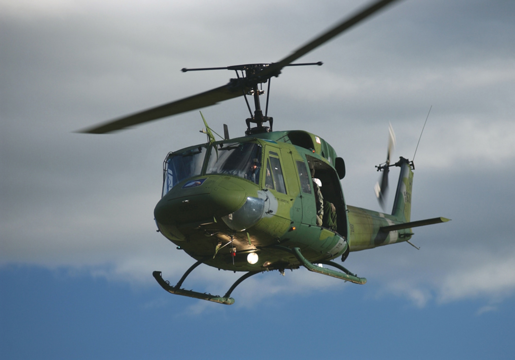 Huey soars above the cloudy skies of Vandenberg on a training mission.
