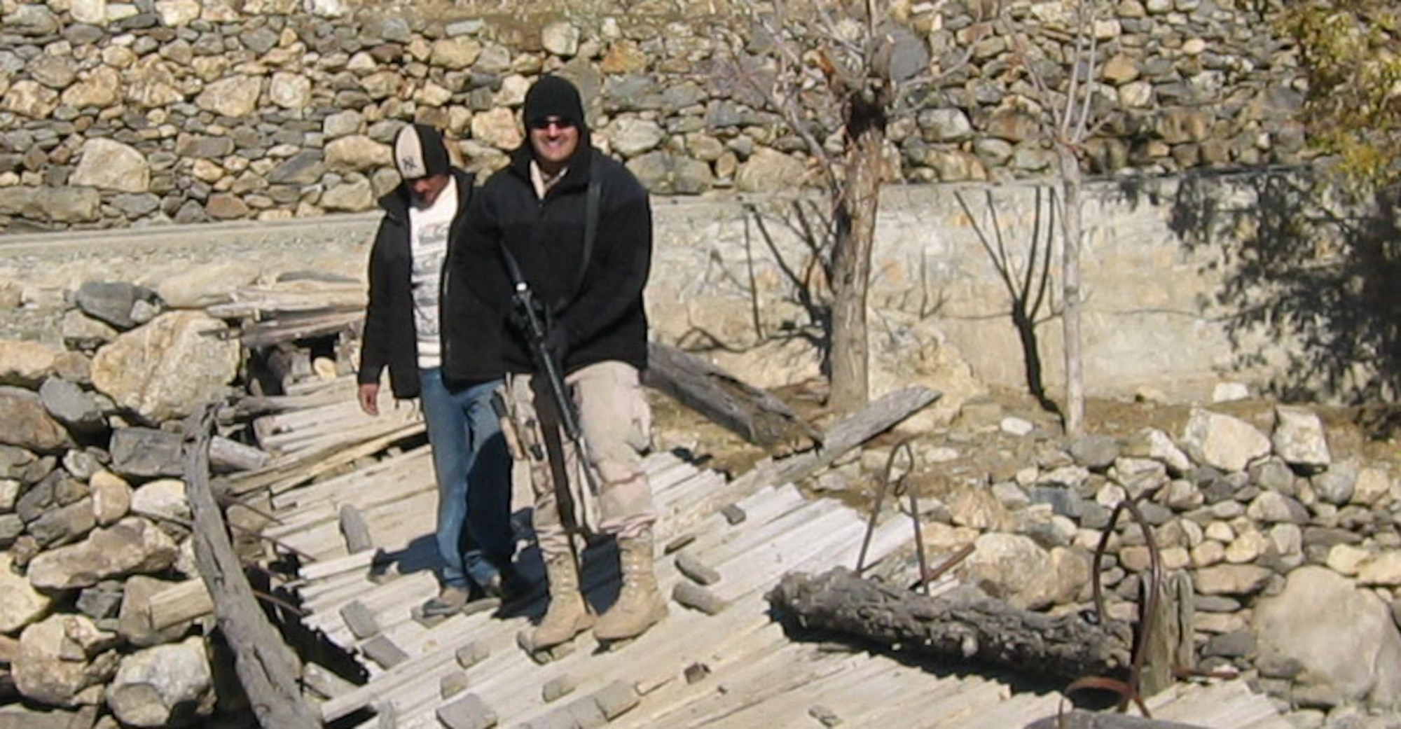 Staff Sgt. Chad Louis and an interpreter cross a broken bridge at the site of a future project to replace bridges in Rakh, Afgahnistan. Sergeant Louis and the interpreter
were members of a 25 person provincial reconstruction team stationed in Afgahnistan.