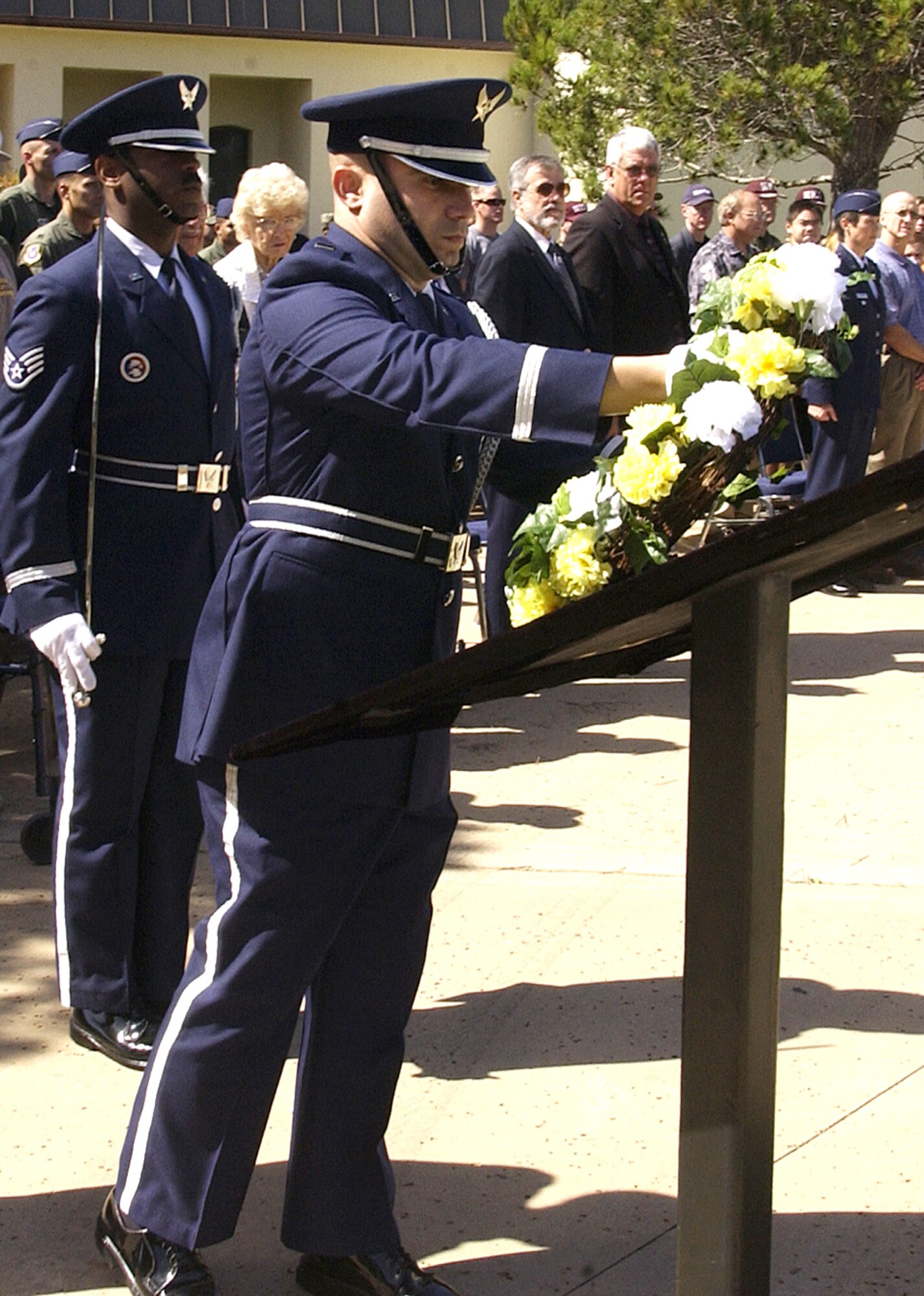 Members of the Vandenberg Honor Guard place a wreath in memory of the military members still missing in action as a helicopter from the 76th Helicopter Squadron completed a flyover.