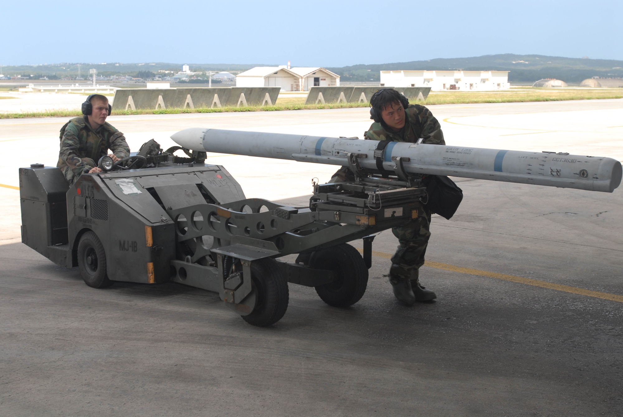 Airman 1st Class Dustin Fox (driving) and Staff Sgt. Fong Vang prepare to load an AIM-120 air-to-air missile on an F-15 Eagle during an combat capability exercise Oct. 18 at Kadena Air Base, Japan. The 18th Wing exercise from Oct. 13 to 19 tested the wing's ability to respond to a wartime situation. Both Airman Fox and Sergeant Vang are from the 18th Aircraft Maintenance Squadron. (U.S. Air Force photo/Tech. Sgt. Dave DeRemer) 