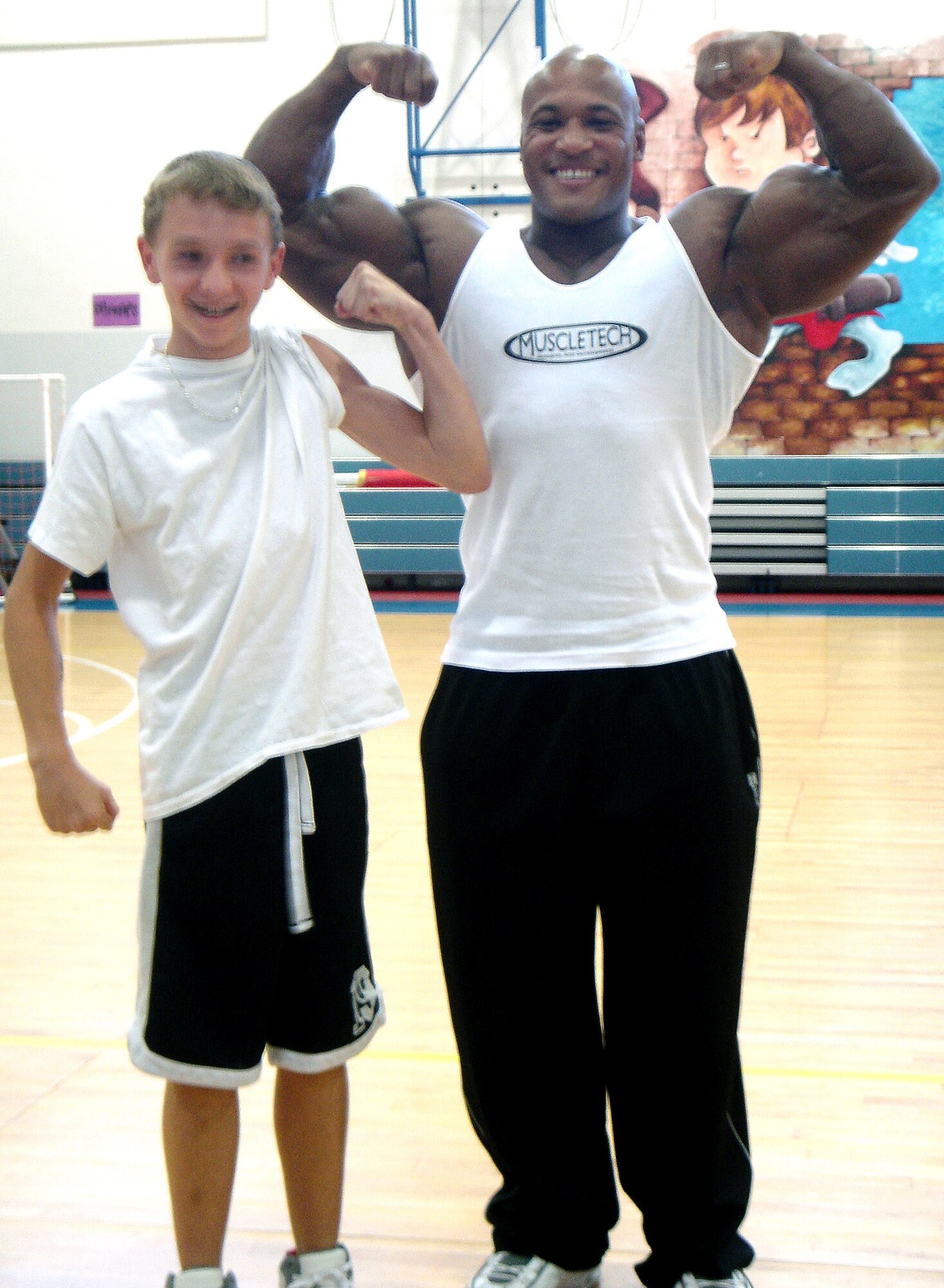 Shaun McElroy, left, flexes with Craig ‘The Diamond’ Richardson during Mr. Richardson’s visit to Aviano Middle School. (Courtesy photo) 