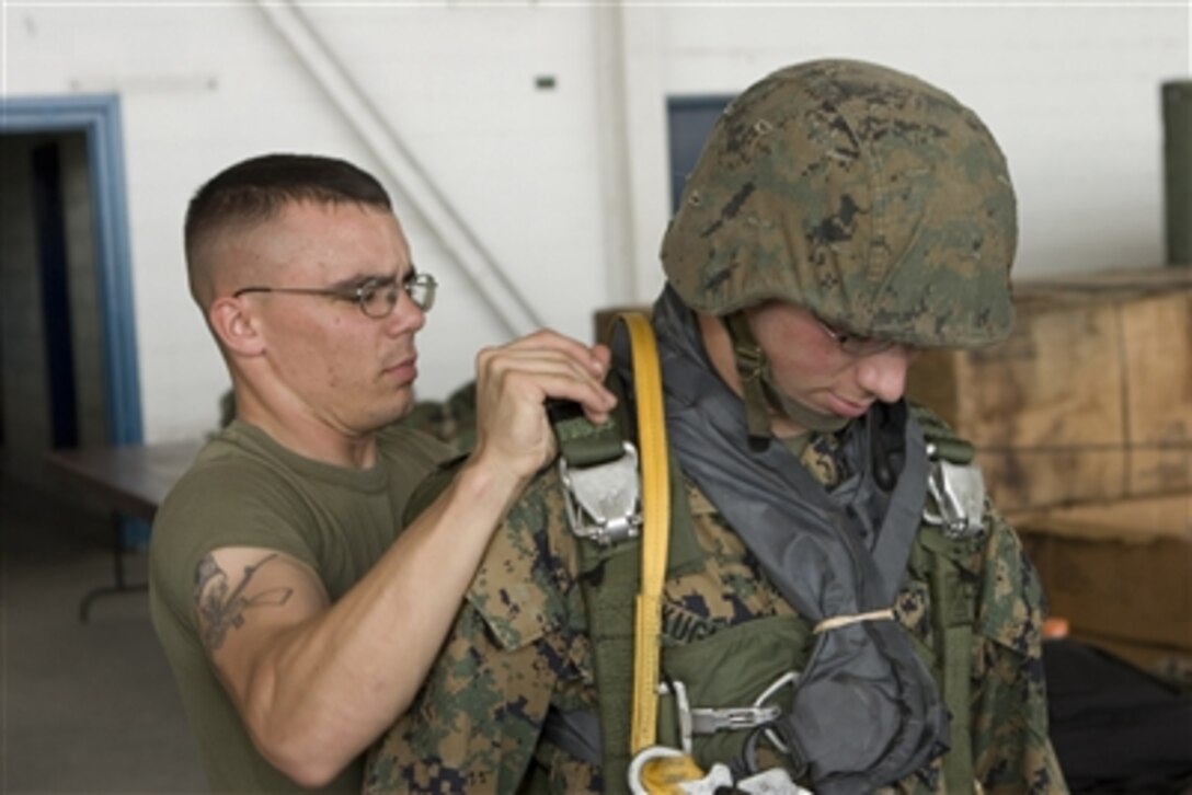 U.S. Marine Corps Sgt. Adam Remillard (left) inspects Lance Cpl. James Kuglar's parachute equipment in a hangar at Clark Air Base, Philippines, on Oct. 18, 2006.  The Marines are participating in Exercises Talon Vision and Amphibious Landing Exercise '07.  The two annual exercises are designed to enhance interoperability between the U.S. and Philippine armed forces.  
