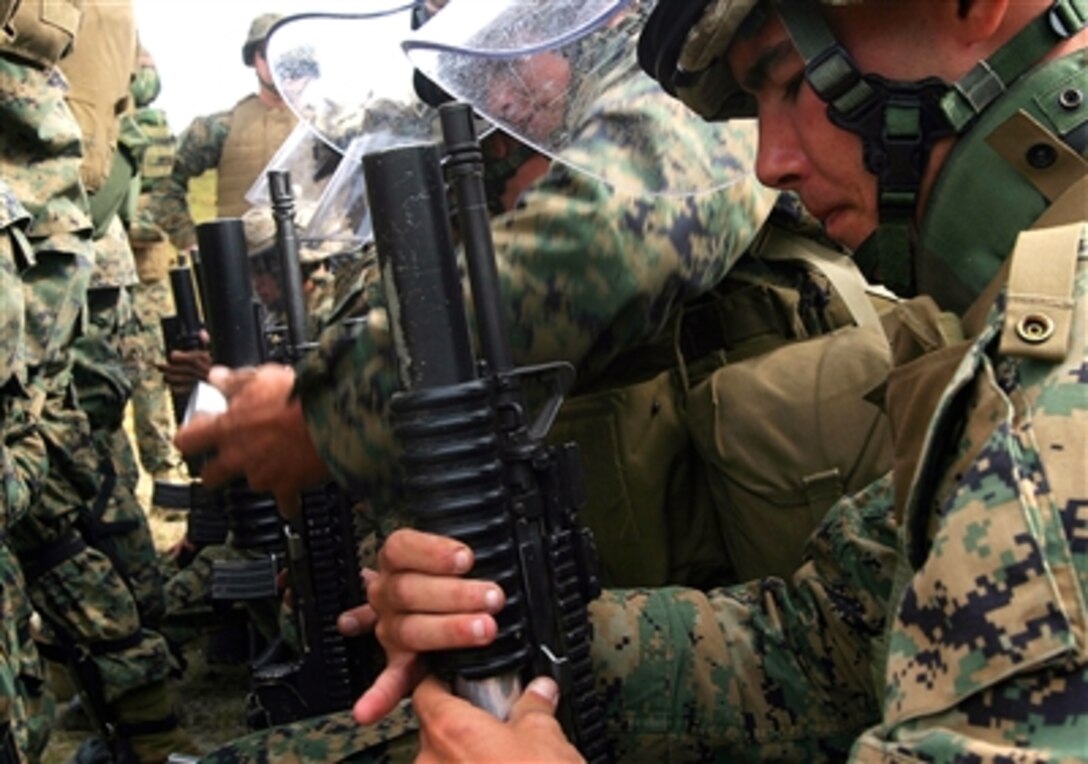 U.S. Marine Corps Lance Cpl. Lee M. Carter loads a foam baton round into his M203 grenade launcher during non-lethal munitions formation live-fire training aboard Marine Corps Base Camp Lejeune, N.C., Oct. 16, 2006. 