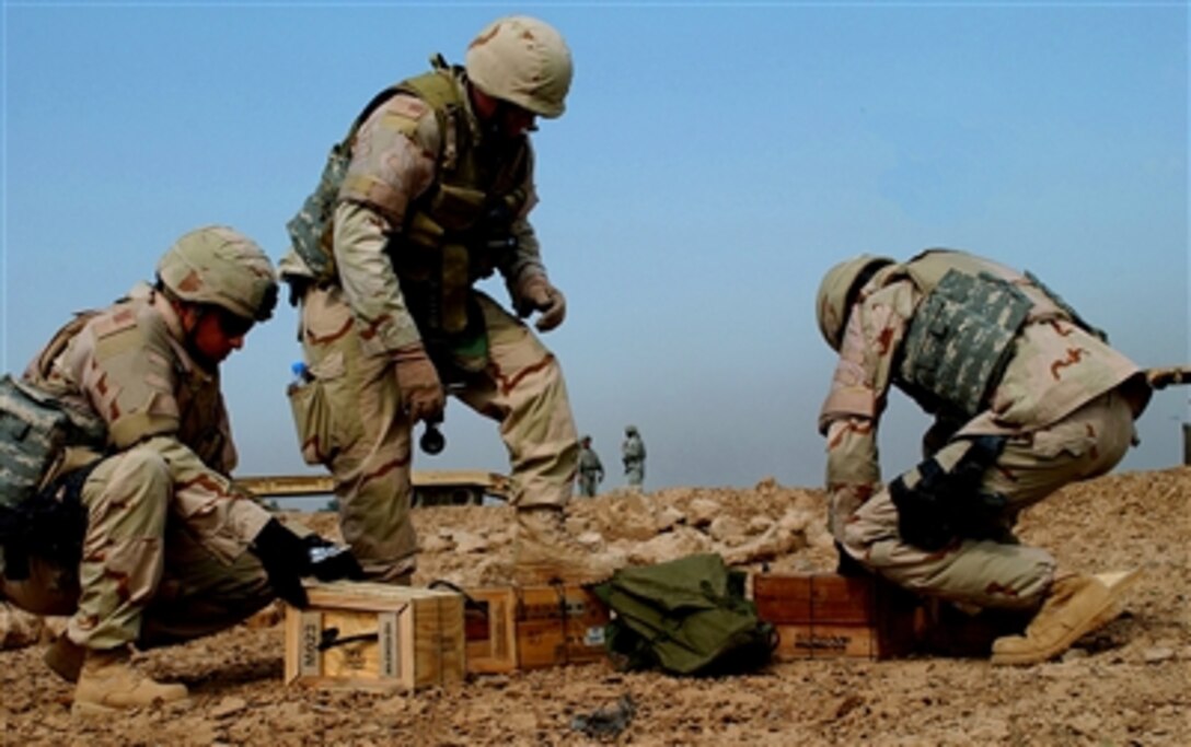 Members of a U.S. Air Force explosive ordnance disposal team unpack C-4 explosives, Oct. 16, 2006. The exposives will be used to detonate a cache of unexploded ordnance recovered from a blast area on Forward Operating Base Falcon, Iraq, following a recent mortar attack. The airmen are assigned to the 447th Expeditionary Civil Engineering Squadron.