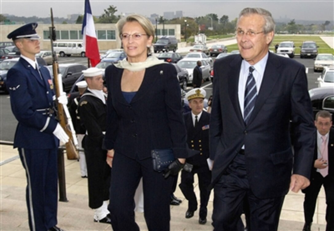 Secretary of Defense Donald H. Rumsfeld escorts French Minister of Defense Michelle Alliot-Marie through a cordon of honor guards and into the Pentagon, Oct. 19, 2006. The two defense leaders met to discuss a range of international issues of mutual interest.   
