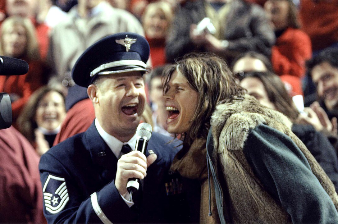 Master Sgt. Steve Thulon, a vocalist with the U.S. Air Force Band of Mid-America, sings with Steven Tyler, lead singer of Aerosmith, at a National League playoff game Oct. 14 at Busch Stadium in St. Louis. The two sang "God Bless America" during the seventh-inning stretch. Sergeant Thulon finished up the break with "Take Me Out to the Ballgame." He said it was an experience he will always remember. Sergeant Thulon was scheduled to sing alone but when the St. Louis Cardinals staff saw Mr. Tyler in the crowd they asked him for an impromptu performance. The Air Force vocalist said he was honored to back up the rock star. "It was a true win-win situation for the Air Force," Sergeant Thulon said. "They threw me a curve ball, but I hit it out of the park." The St. Louis Cardinals represent the National League in the upcoming World Series against the American League's Detroit Tigers. (Courtesy photo/St. Louis Cardinals)