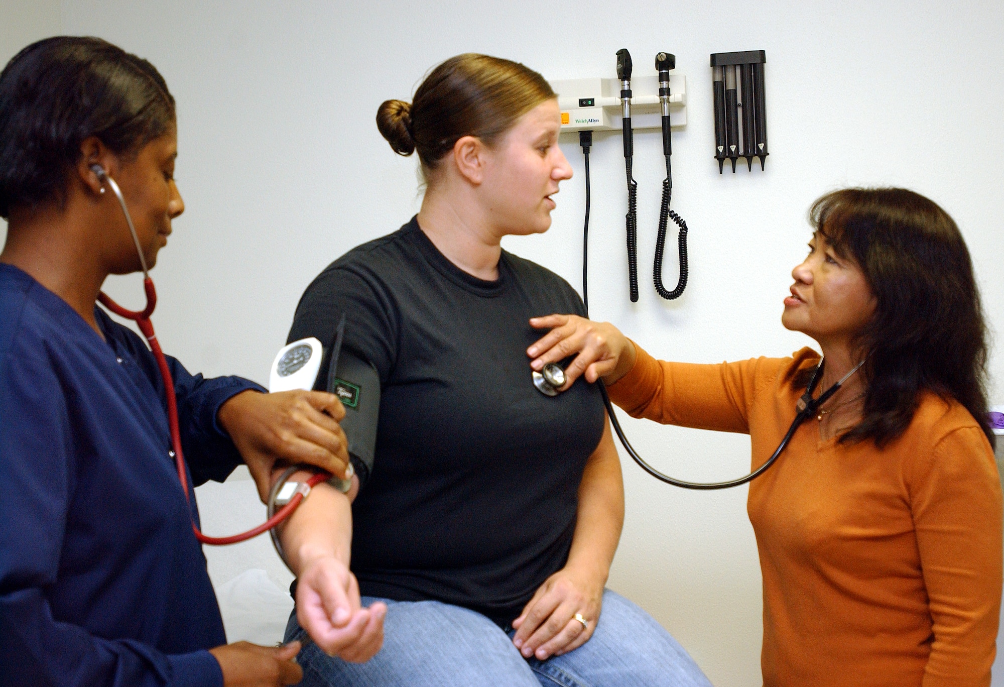 Gina Atkinson, right, the new family nurse practitioner in the 97th Medical Group, and licensed practical nurse Betty Gibson, left, examine a patient in the Family Practice Clinic Tuesday.  The addition of Ms. Atkinson to the medical staff allows the 97th MDG to once again provide women's health services. (U.S. Air Force photo by Staff Sgt. Monique Randolph)