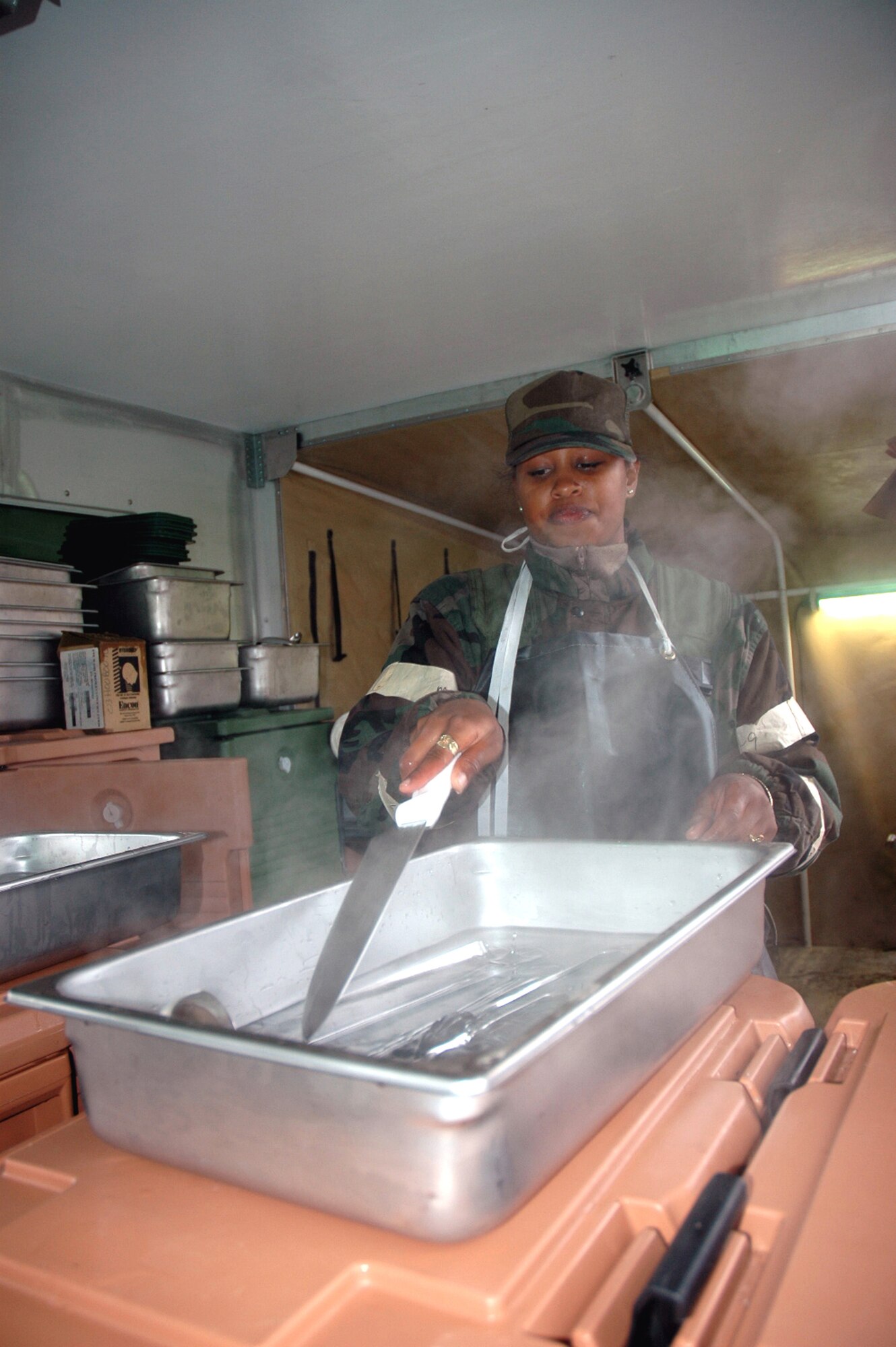 Senior Airman Joanna Houston works in a mobile field kitchen preparing hot meals during operations for Air Force Exercise Eagle Flag 07-1 Oct. 17 at Naval Air Engineering Station Lakehurst, N.J. Airman Houston was one of more than 400 Airmen participating in the exercise that tests expeditionary combat support skills. The exercise is operated by the Air Mobility Warfare Center's 421st Combat Training Squadron at Fort Dix, N.J. Airman Houston is a services journeyman from the 5th Services Squadron, Minot Air Force Base, N.D. (U.S. Air Force photo/Tech. Sgt. Scott T. Sturkol)
