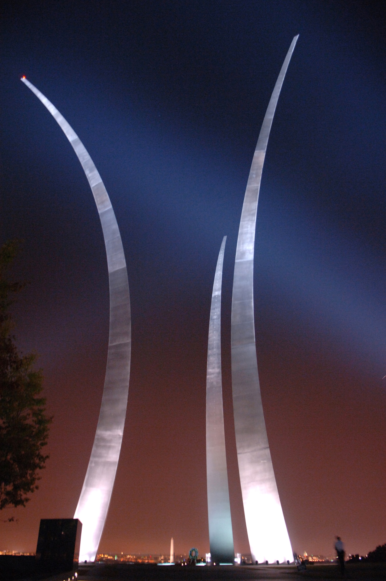 The Air Force Memorial spires soar toward the night sky, the lights of nearby Washington D.C. glowing in the background.  Designed by the late James Ingo Freed, the memorial pays tribute to and honors the patriotic men and women of the U.S. Air Force and its predecessor organizations.  (U.S. Air Force photo/Tech. Sgt. Christopher J. Matthews)