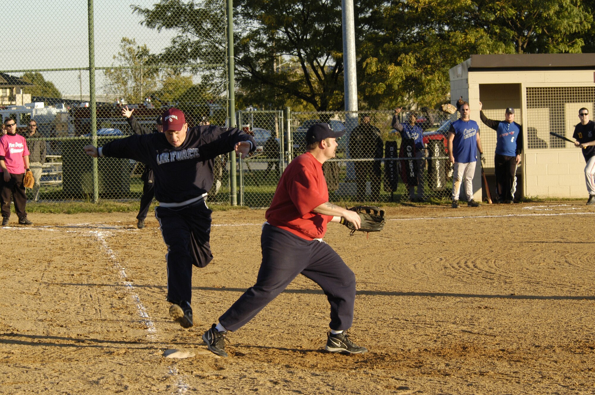 Tech. Sgt. Michael Bartels, 436th Security Forces Squadron, makes it safely to first base while John Melvin, 436th Civil Engineer Squadron Fire Department, waits for the throw during the annual Battle of the Badges softball games Oct. 13. The Fire Dogs defeated the Cops 15 - 9 after seven innings. (U.S. Air Force photo by Senior Airman James Bolinger)