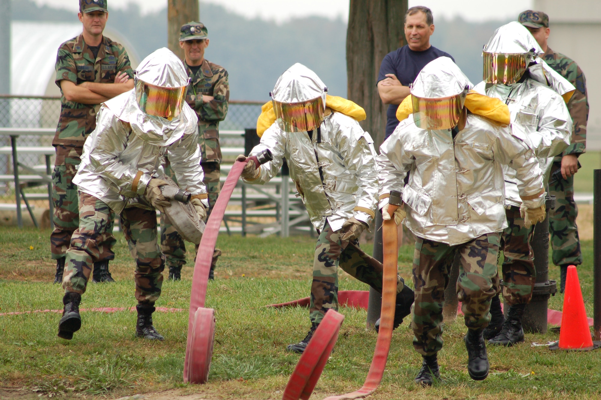 (Left to right) Chief Master Sgt. Larence Kirby, 436th Medical Group superintendant, Chief Master Sgt. Bruce Blodgett, 436th Airlift Wiing command chief and Chief Master Sgt. Michael Branum, 436th Aerial Port Squadron, roll lengths of house during Dover Air Force Base's first annual fire muster. The object of the first event of the muster was to connect three hoses together, attach them to a fire hydrant and show water coming out of the hose without any leaks at the connection points. (U.S. Air Force photo/Senior Airman James Bolinger)