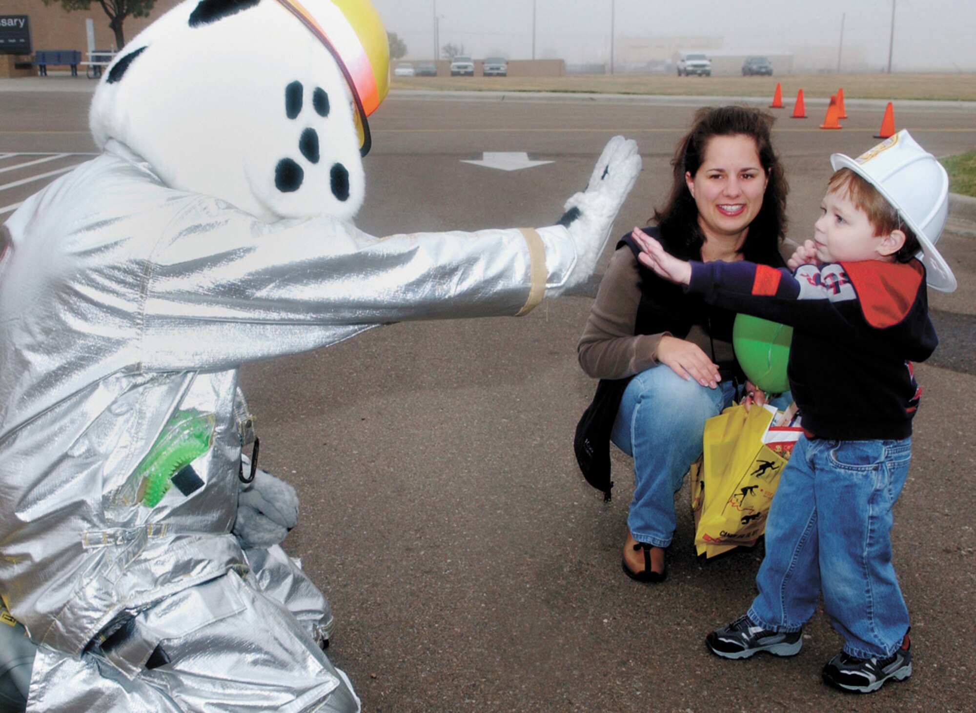 CANNON AIR FORCE BASE, N.M. -- Sparky, a Cannon Fire Fighter, kept the Fire Prevention Week festivities going by doing a live appearance at the base exchange Oct. 14. While  there, he met with junior fire detector Thomas Cluverius, 2, and his mother Laura about fire safety at home. Thomas’ dad, Tech. Sgt. Michael Cluverius, is deployed to Balad Air Base, Iraq, from the 27th Equipment Maintenance Squadron. (U.S. Air Force photo/ Airman 1st Class Erik Cardenas)

