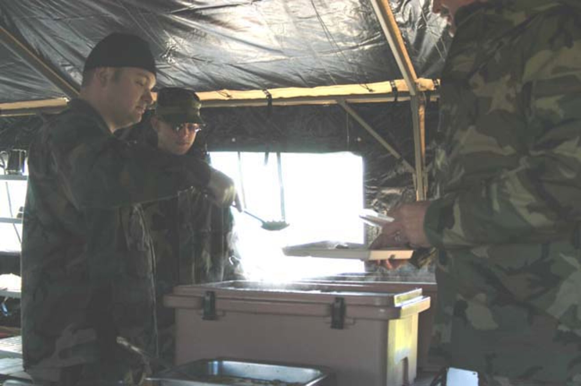 GRISSOM AIR RESERVE BASE, Ind -- Tech. Sgt. Logan Phillippe (foreground) and Senior Airman Joseph McDonald of the 434th Services Flight serve lunch using the new Single Palletized Expeditionary Kitchen.  The kitchen was put to use during a recent Unit Training Assembly and can serve 600 people in about two hours. (U.S. Air Force photo/Senior Airman Roberto Modelo)
