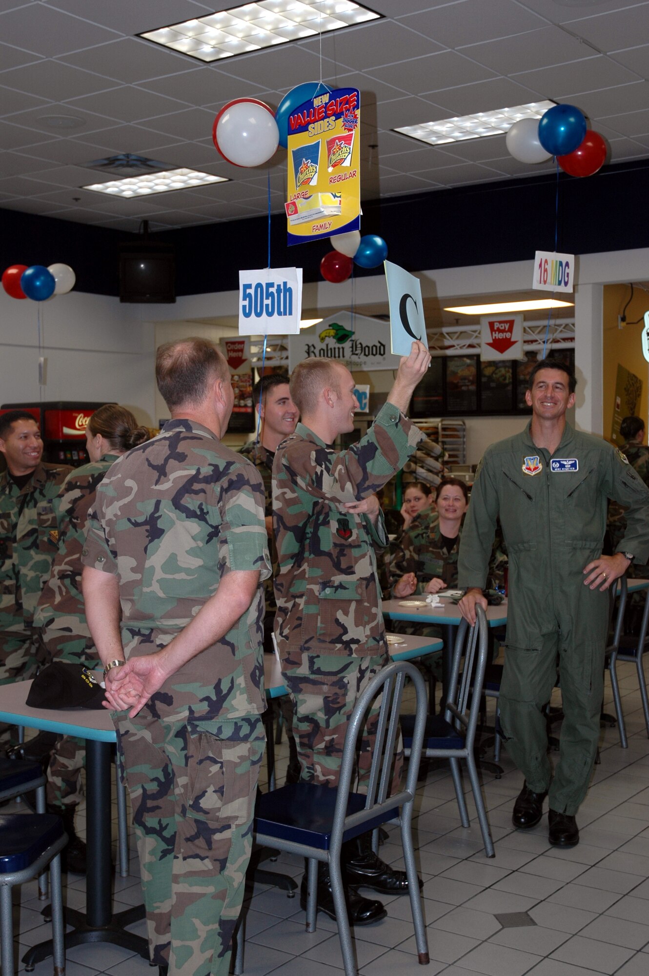 An Airman from the 505th Command and Control Wing holds up his table's answer to a question during the "CFC Survivior" game at the Combined Federal Campaign mid-campaign rally held Wednesday in the mini-mall.  More than $240,000 at the half-way point in the campaign. (U.S. Air Force Photograph by Jamie Haig)