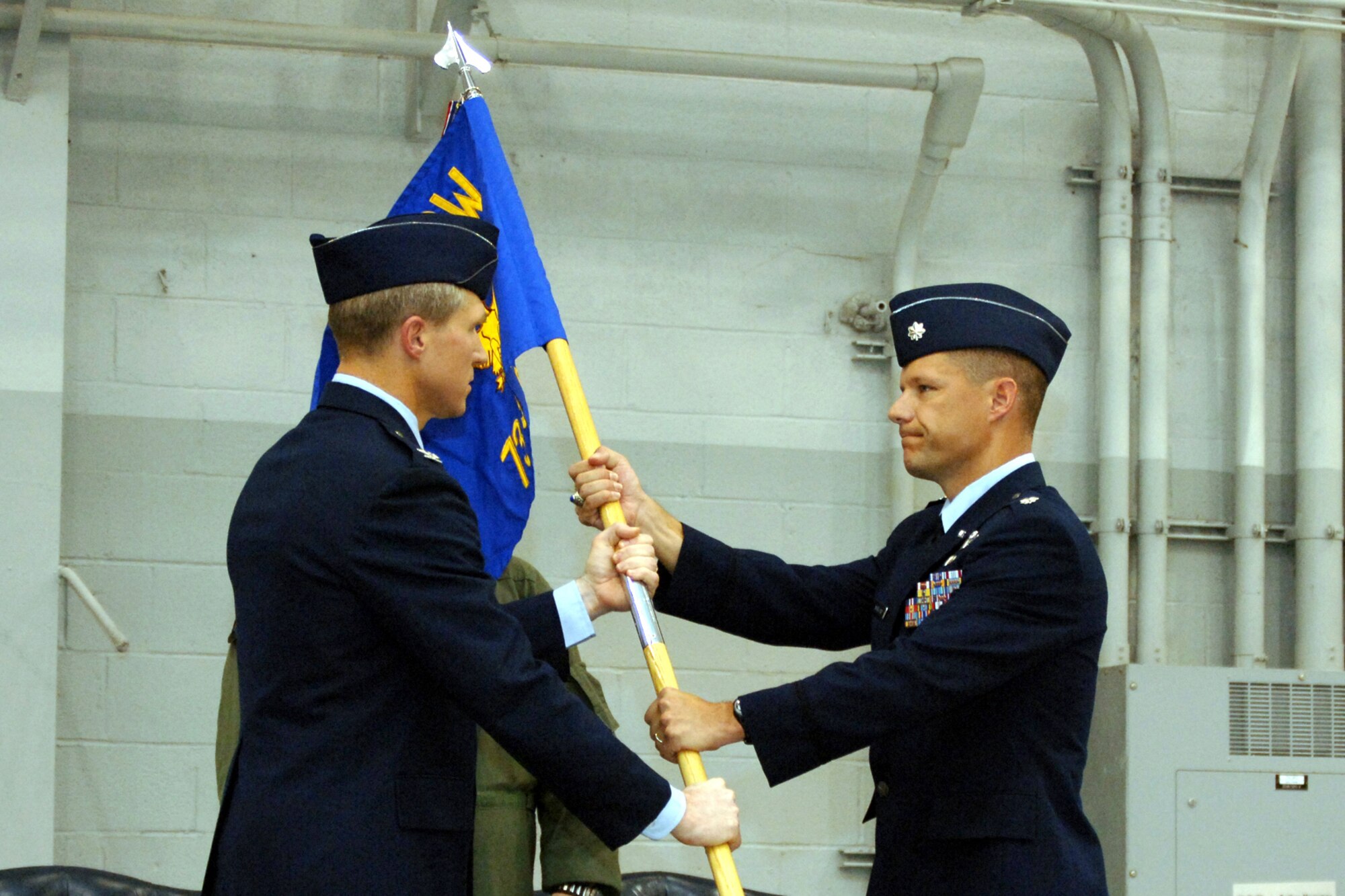 Col. Mark Alsid, 16th Operations Group commander, passes Lt. Col. Tom Markland, 73rd Special Operations Squadron commander, the guidon during the stand-up ceremony Tuesday in Commando Hangar. (U.S. Air Force Photograph by Airman 1st Class Stephanie Sinclair)
