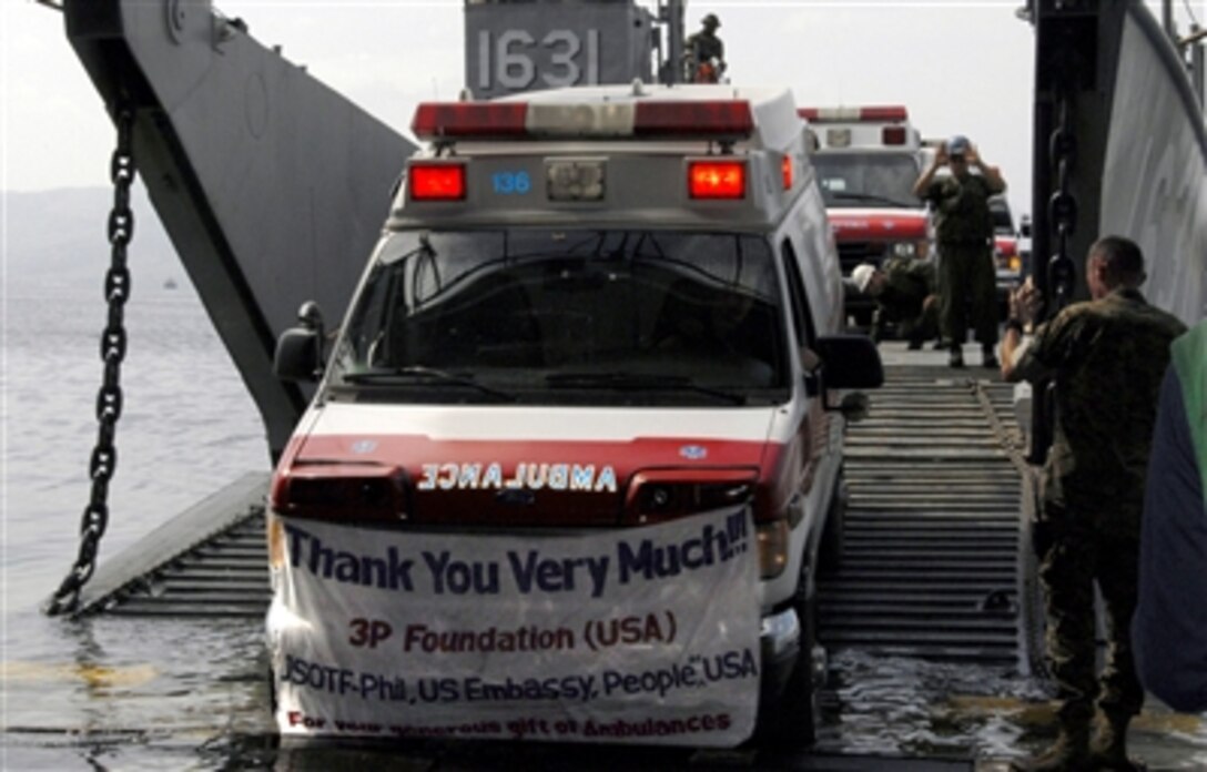 Ambulances, donated by the Seattle-based 3P Foundation, are driven off of Landing Craft Utility 1631 into the well deck of the USS Harpers Ferry in Subic Bay Freeport, Philippines, Oct. 18, 2006. The ambulances will be distributed to Zamboanga, Jolo and Tawi Tawi in the southern Philippines.