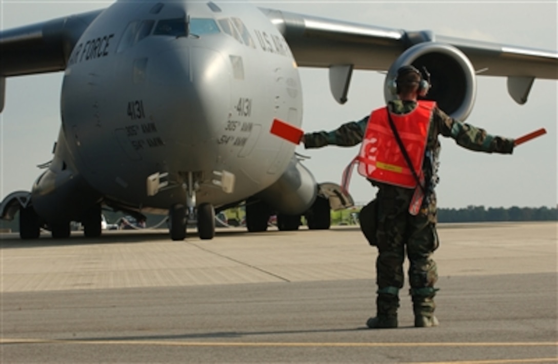 A U.S. Air Force crew chief directs the pilot of a C-17 Globemaster III aircraft into position on the parking ramp during exercise Eagle Flag 07-01 at Naval Air Engineering Station Lakehurst, N.J., on Oct. 18, 2006.  Eagle Flag is an annual exercise designed to prepare military members for the rigors of combat in a deployed environment.  