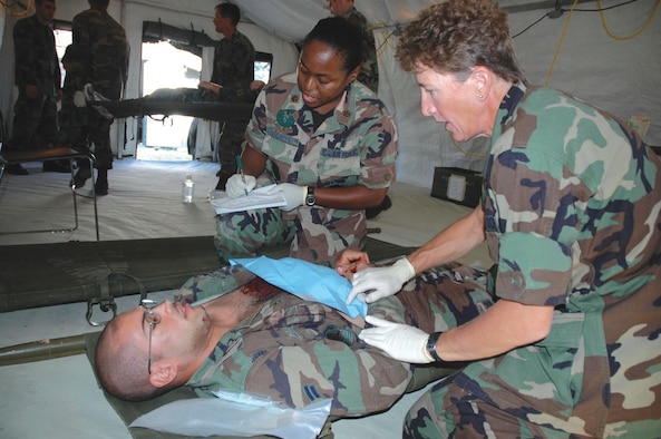 TYNDALL AFB, Fla. --  Majors Lisa Mitchell and Norreen Burke administer simulated emergency medical care on Airman 1st Class Rogue Utero-Ostolaza, 325th Operational Support Squadron, during the 325th Medical Group's annual expeditionary readiness exercise here Oct. 7. (U.S. Air Force photo by 1st Lt. Jon Quinlan)