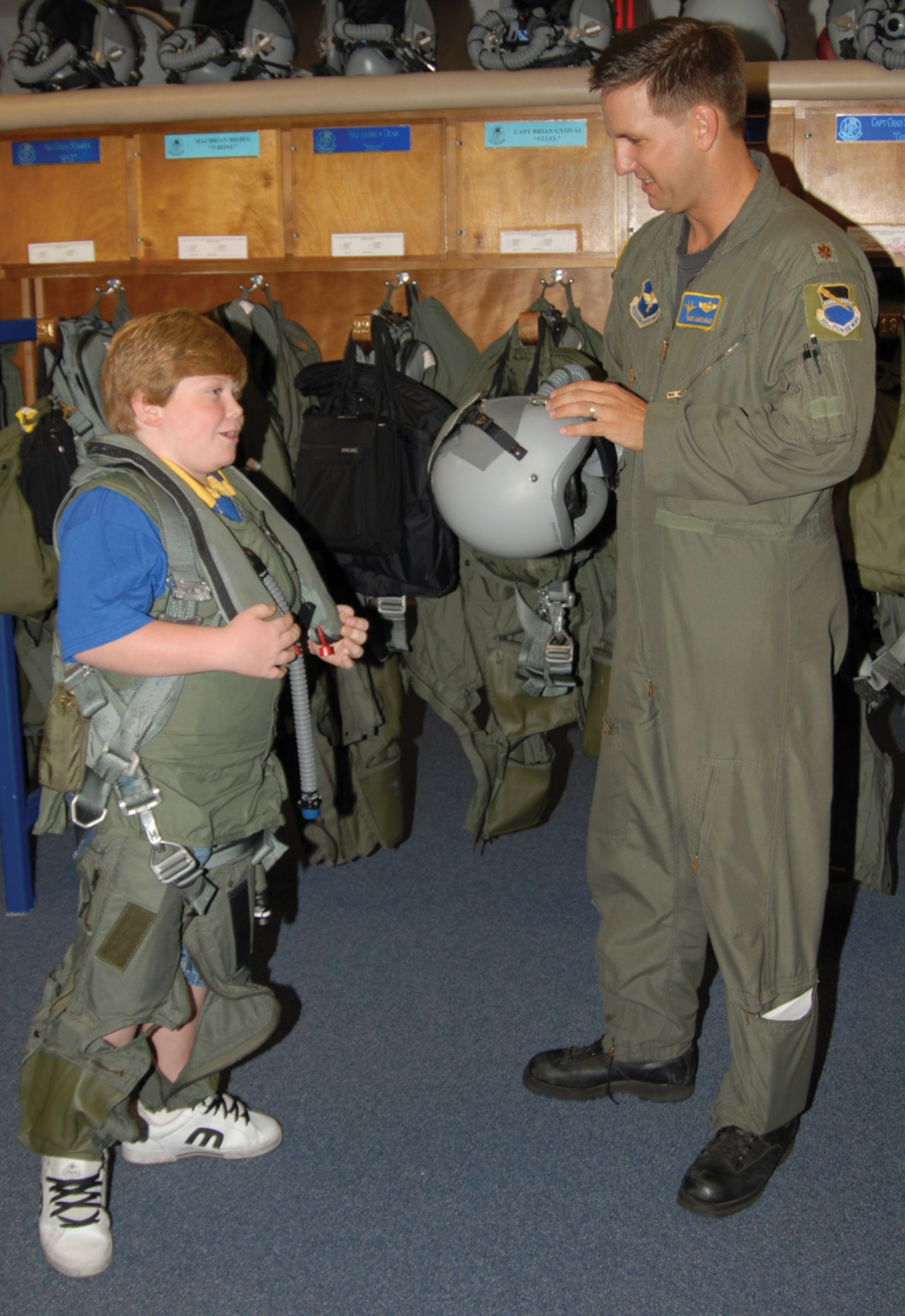 TYNDALL AFB, Fla. --  Maj. Nick Kavouras, 95th Fighter Squadorn instructor pilot, shows Ryan McGraw the gear pilots wear during flight. Ryan participated in the second Pilot for a Day hosted by the 95th FS here. (U.S. Air Force photo by Lisa Norman)