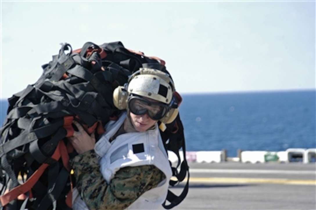 A U.S. Marine carries cargo netting across the flight deck of the amphibious assault ship USS Bataan during a vertical replenishment with ammunition ship USNS Mount Baker in the Atlantic Ocean, Oct. 21, 2006. Bataan is conducting training in preparation for an upcoming deployment. 