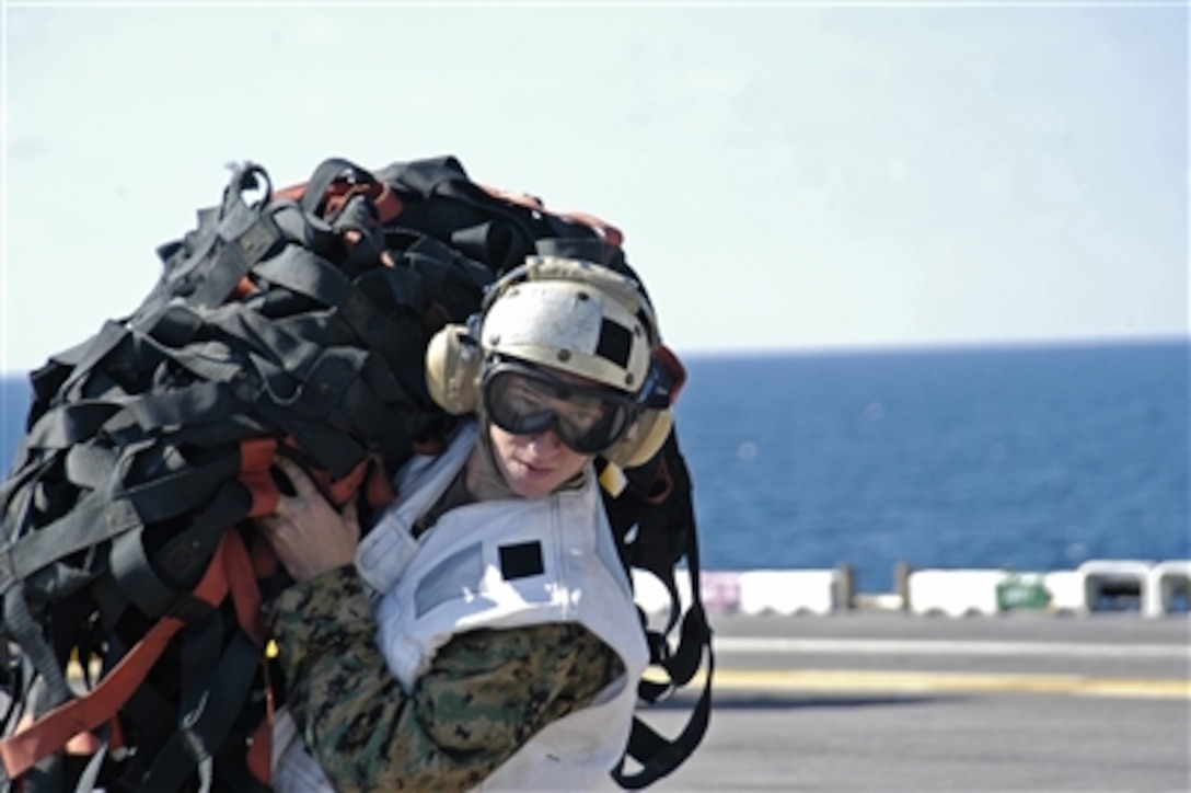 A U.S. Marine carries cargo netting across the flight deck of the amphibious assault ship USS Bataan (LHD 5) during a vertical replenishment with ammunition ship USNS Mount Baker (T-AE 34) on Oct. 21, 2006.  The Bataan is under way in the Atlantic Ocean conducting training in preparation for an upcoming deployment.  