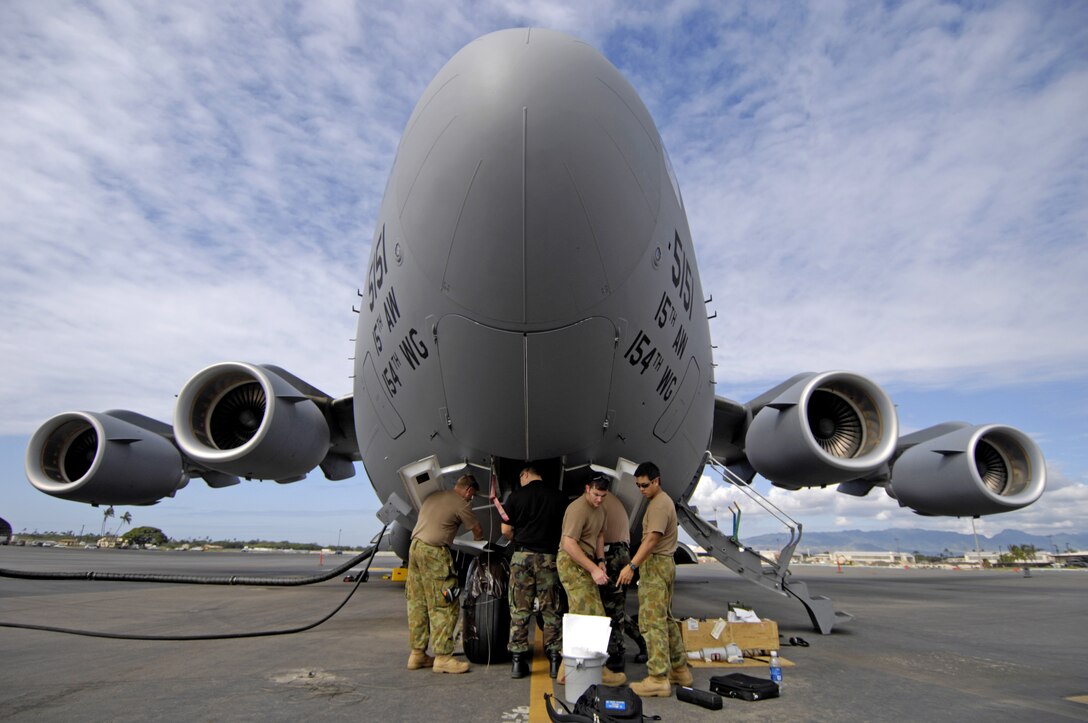 U.S. and Australian maintainers work on a C-17 Globemaster III nose steering actuator at Hickam Air Force Base, Hawaii Oct. 19, 2006.  Maintainers from Amberly Royal Australian Air Force Base's 36th Squadron are working along side their U.S. Air Force counter parts from the 15th Maintenance Group learning the ins and outs of the Globemaster III in preparation for the delivery of their first C-17. (U.S. Air Force photo / Tech. Sgt. Shane A. Cuomo)
