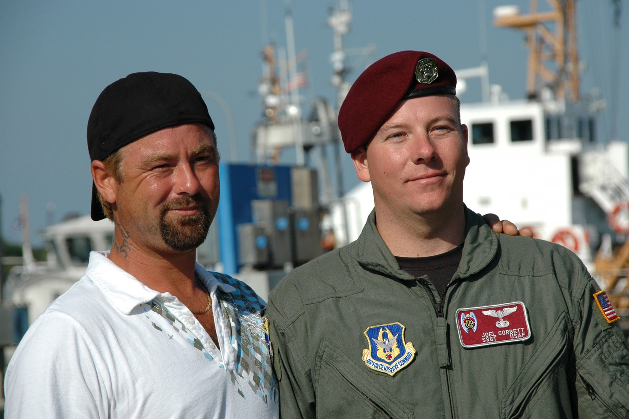 Staff Sgt. Joel Corrbett, a pararescuman with the Air Force Reserve's 920th Rescue Wing, stands with Clinton Doughtry on the docks of Coast Guard Sector Jacksonville headquarters. Mr. Doughtry and four friends were rescued at sea after a boating incident Oct. 1.  Mr. Doughtry was the first save of Sergeant Corrbett's pararescue career. (U.S. Air Force photo/Senior Airman Jonathan Simmons)