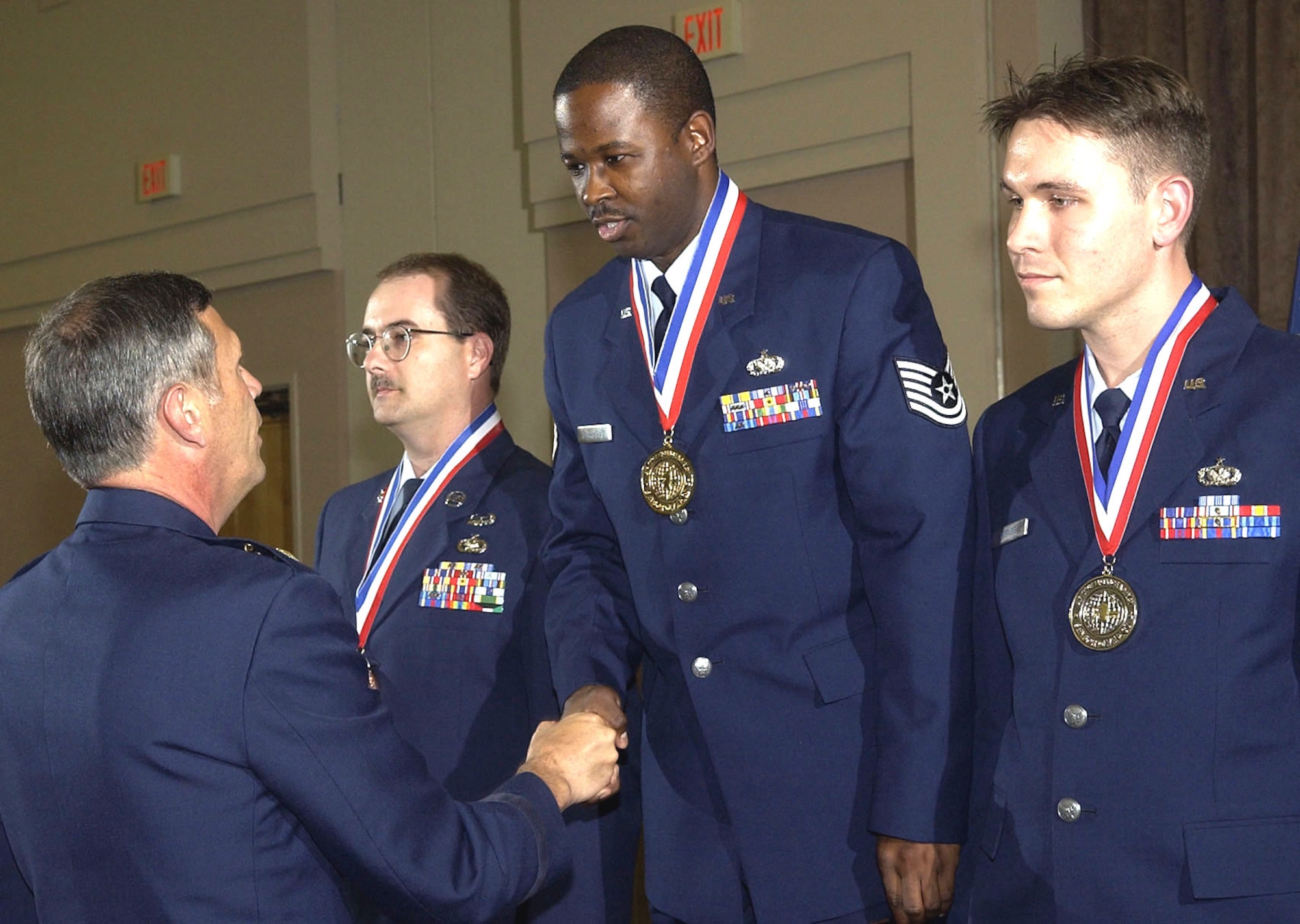 Maj. Gen. Craig Koziol, Air Intelligence Agency commander, congratulates Tech. Sgt. George McFarland, gold medal recipient for the 2S0X1 Supply Management career field.  Sergeant McFarland is from the 373rd Support Squadron, Misawa Air Base, Japan.  Silver medalist for the career field is Tech. Sgt. Paul Reeves, 488th Intelligence Squadron, RAF Mildenhall, England. Bronze medalist is Tech. Sgt. Anthony Bussey, Air Force Information Operations Center, Lackland Air Force Base, Texas. Gold, silver and bronze medals were awarded to the top three enlisted specialists in each of 23 career fields within AIA on Oct. 19, at the 27th Annual Sensor Olympics Banquet at the Lackland AFB Gateway Club. (U.S. Air Force photo/Ted Koniare)