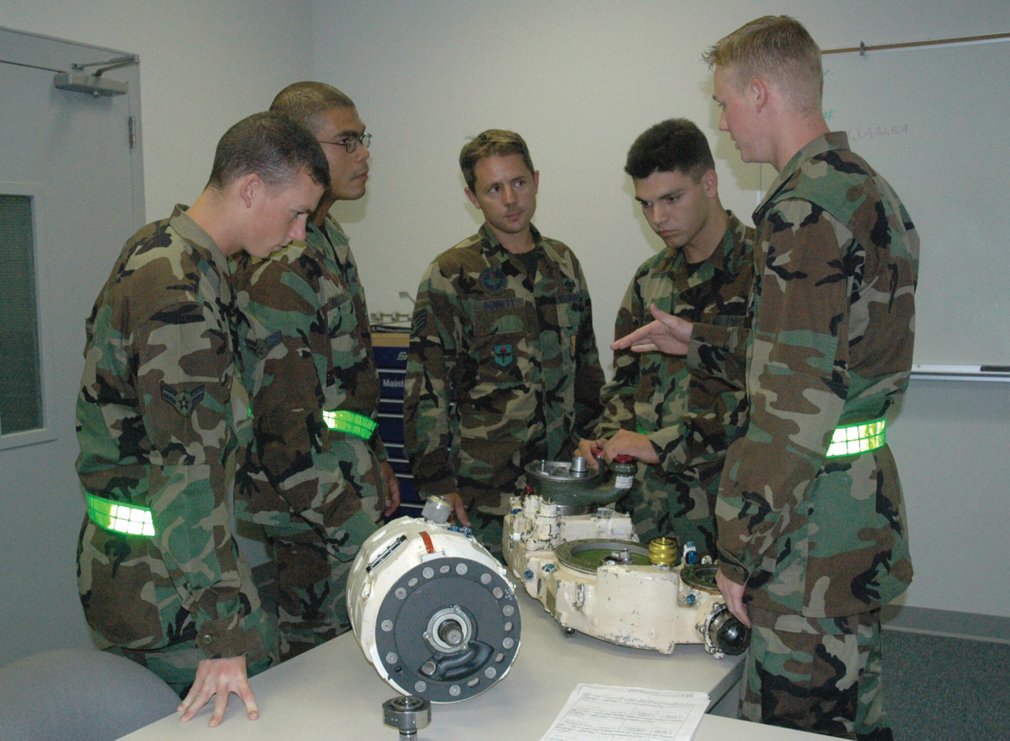 TYNDALL AFB, Fla. --  Airman Basic Joshua Dawson, 372nd Training Squadron/Detachment 4 mission ready airman (right), explains how to service an integrated drive generator to his instructor and fellow Airmen. The generator supplies electrical energy to F-15 Eagle aircraft. Trainees from Class 2006069 graduated Thursday and are now mission ready F-15 crew chiefs. (U.S. Air Force photo by Chrissy Cuttita)
