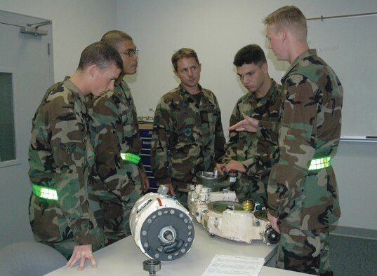 TYNDALL AFB, Fla. --  Airman Basic Joshua Dawson, 372nd Training Squadron/Detachment 4 mission ready airman (right), explains how to service an integrated drive generator to his instructor and fellow Airmen. The generator supplies electrical energy to F-15 Eagle aircraft. Trainees from Class 2006069 graduated Thursday and are now mission ready F-15 crew chiefs. (U.S. Air Force photo by Chrissy Cuttita)