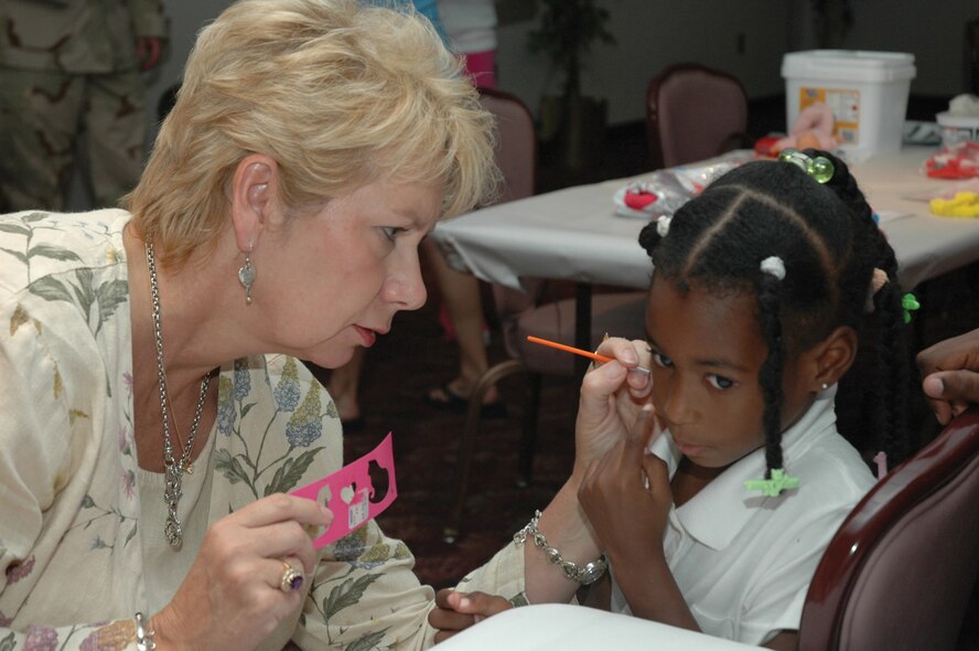 TYNDALL AFB, Fla. --  Christina Jones points to where she wants a heart painted on her face by Jan Sheffield, a family readiness consultant from the Airman and Family Readiness Center here. More than 100 Tyndall Airmen, who will be deploying over the next few weeks, gathered with their families at the Enlisted Club Aug. 30 for the "Warrior Farewell" ceremony. The ceremony featured activities for children and information from base agencies to help families prepare for the upcoming deployment. (U.S. Air Force photo by 1st Lt. Amanda Ferrell)
