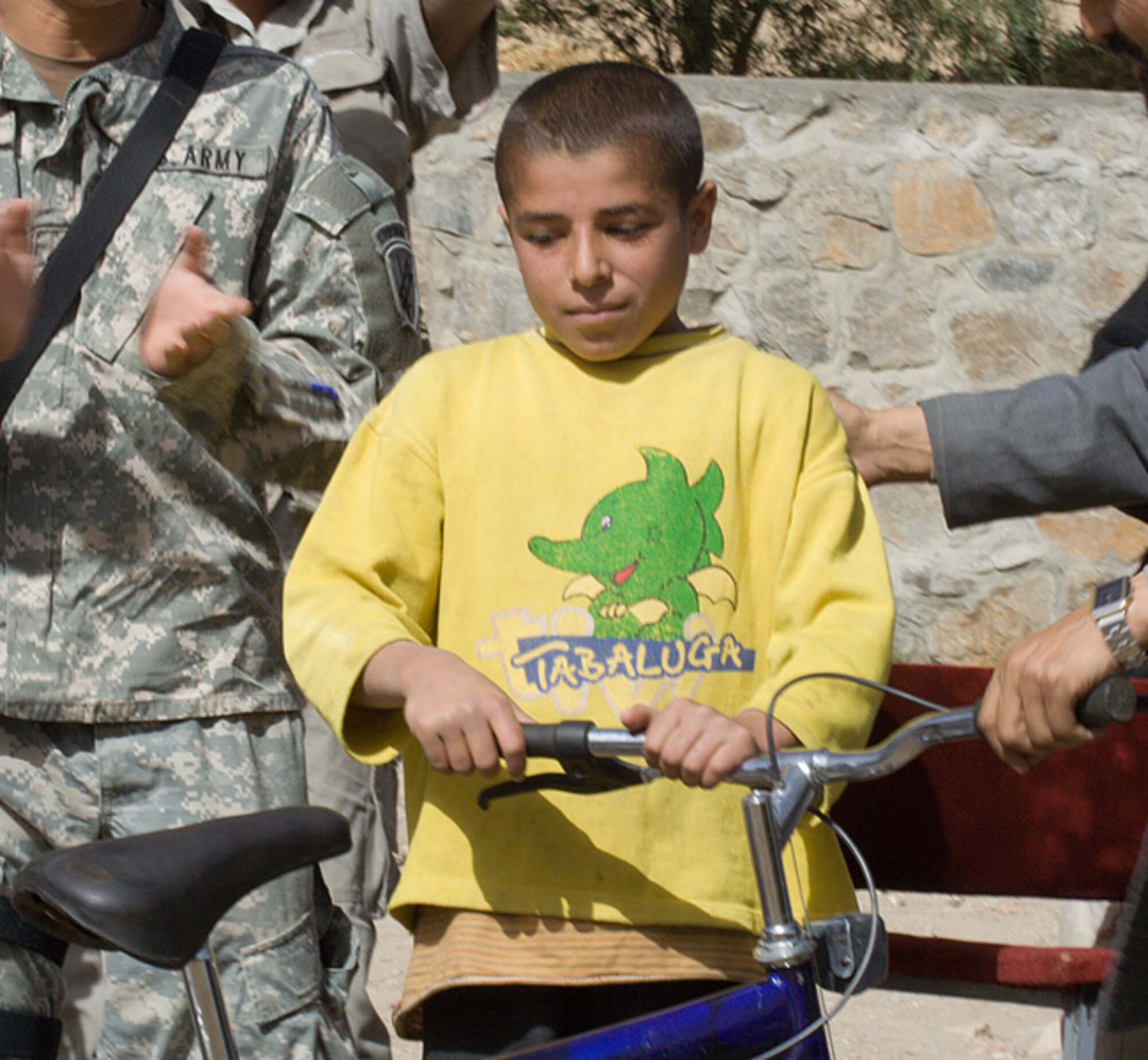 One of the top students at the Rohka School in the Panjshir Province in Afghanistan receives a bicycle for his academic achievements.  The bicycle was given by the Panjshir Provincial Reconstruction Team. The PRT also presented backpacks, pens, pencils, notepads and other donated supplies to students at the school's new well dedication ceremony Oct. 21. (U.S. Air Force photo/Tech. Sgt. John Cumper)