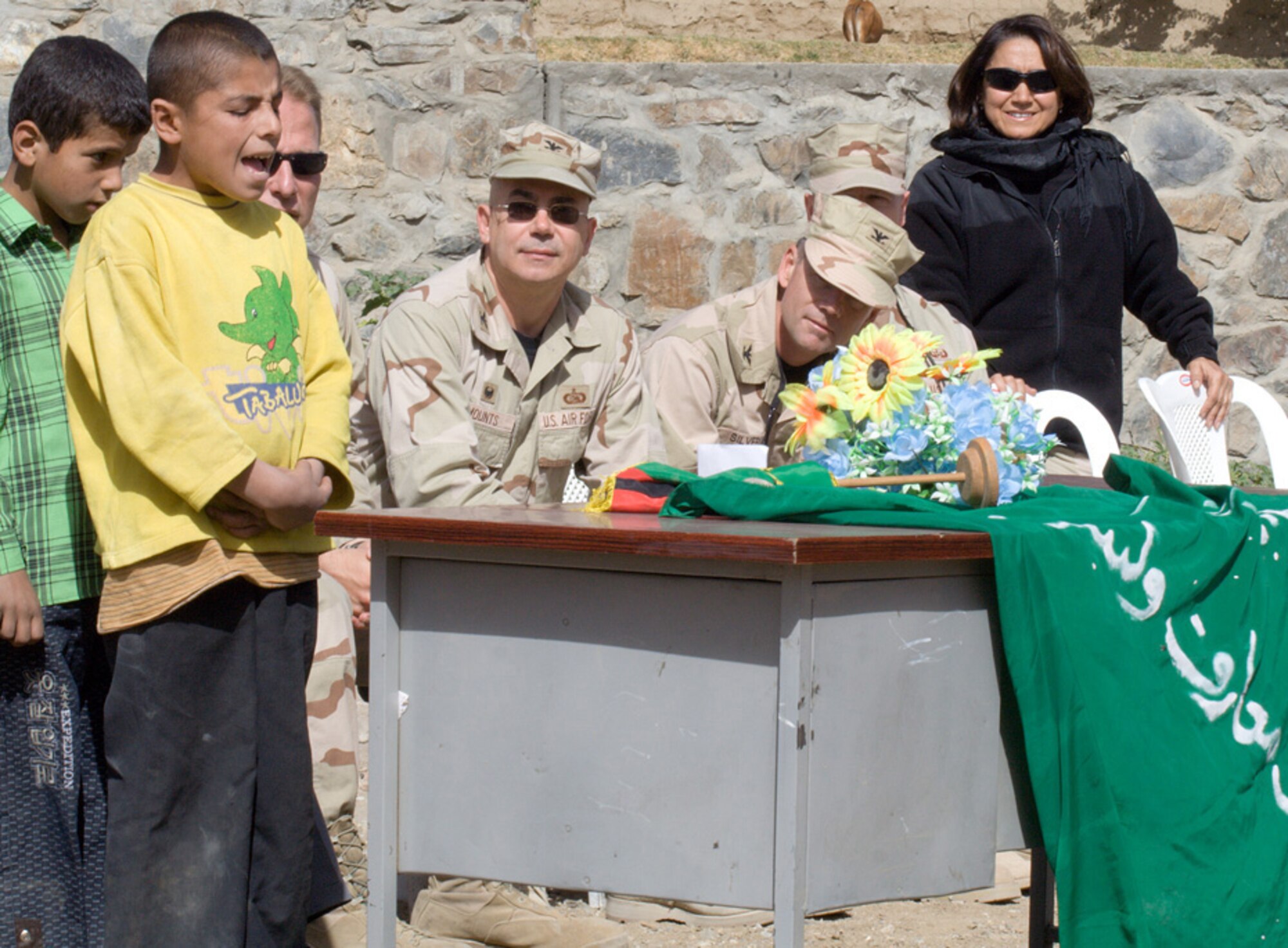 Lt. Col. Neal Kringel, Panjshir Provincial Reconstruction Team commander; Col. Michael Mounts, 755th Expeditionary Mission Support Group commander; Col. Jay Silveria, 455th Air Expeditionary Wing vice commander; Chief Master Sgt. David Williamson, 455th AEW command chief; and Ms. Shahla Hammond, Panjshir PRT interpreter, listen as the top student at Rohka School sings the Afghan national anthem at the school's water well dedication ceremony Oct. 21. (U.S. Air Force photo/Tech. Sgt. John Cumper)