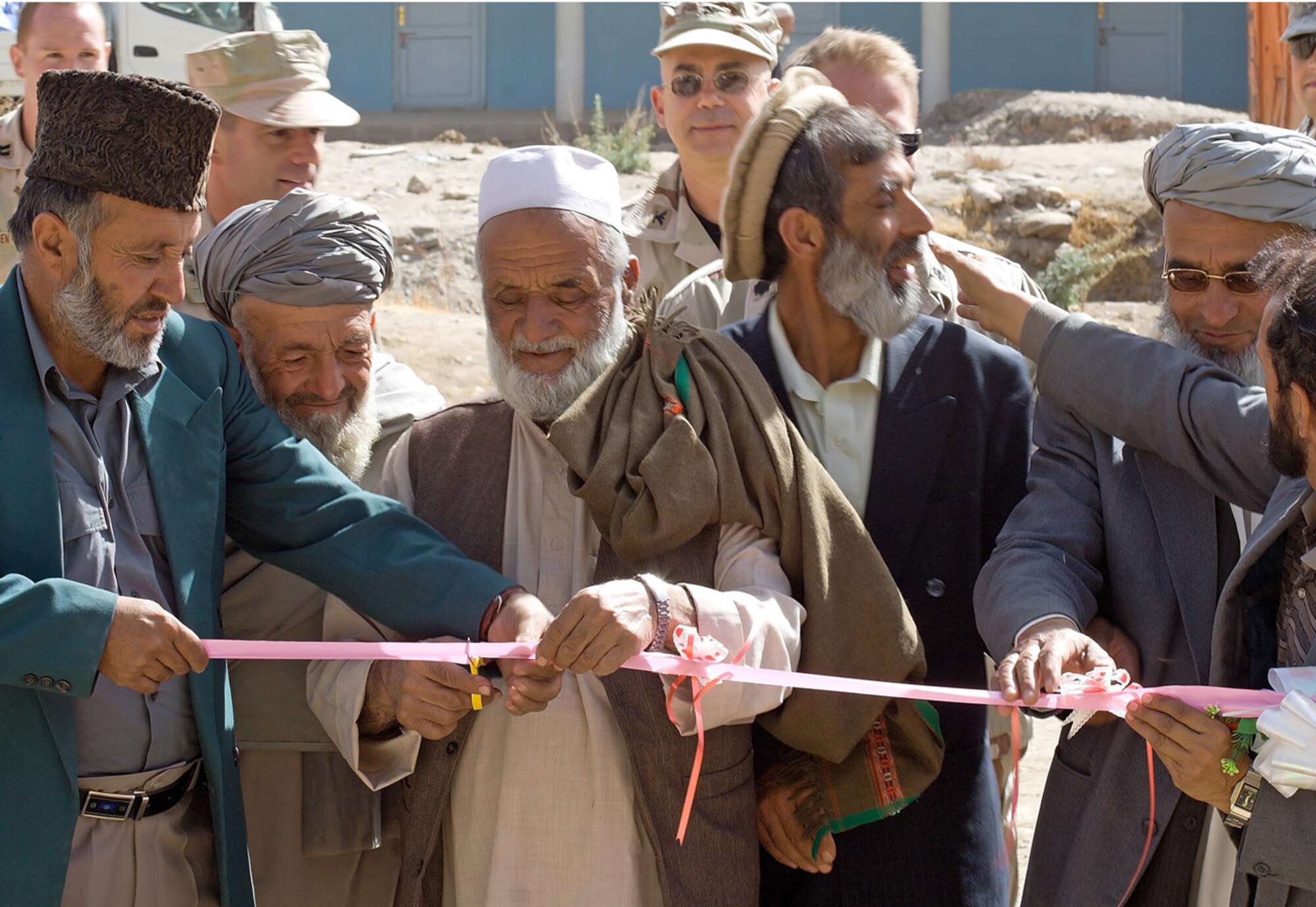 Local Afghan village elders and Rohka School faculty members cut a ribbon marking the dedication of the school's new water well on Oct. 21.  The well was funded by the Panjshir Provincial Reconstruction Team's Commander's Emergency Response Program.  Before construction of the well, students drank water drawn from a nearby irrigation ditch. (U.S. Air Force photo/Tech. Sgt. John Cumper)
