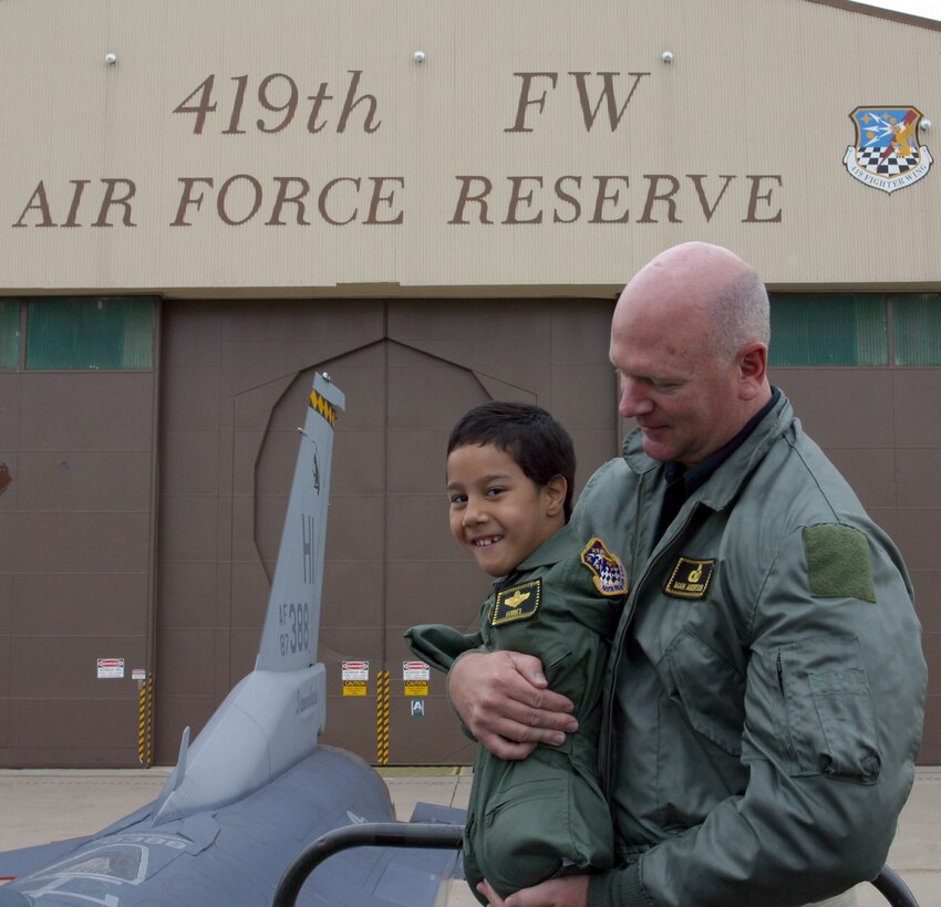 Gabe Adams, who was born with no arms or legs, is carried by his father, Ron Adams, as they prepare to climb into the backseat of an F-16D at the 419th Fighter Wing here Oct. 19.  (U.S. Air Force Photo/Tech. Sgt. Brian Pusey)
