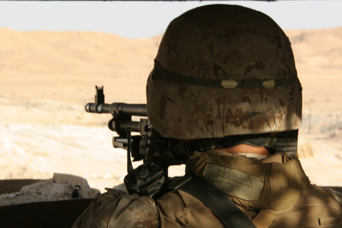 Lance Cpl. Richard D. Pietrulewiez sits behind his M-240G machine gun at the entry point of Traffic Control Point Flea at Al Asad, Iraq, Oct. 24. Pietrulewiez is a greeter at the traffic control point and is with 3rd Squad, 1st Platoon, India Battery, 3rd Battalion, 14th Marine Regiment, 3rd Low Altitude Air Defense Battalion, Marine Wing Support Group 37 (Reinforced), 3rd Marine Aircraft Wing (Forward). He is a native of Allentown, Pa.