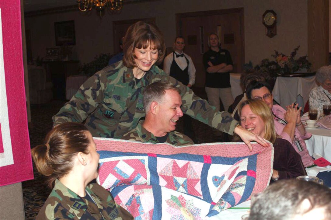 Lt. Col. Jim Sterling, 5th Medical Support Squadron commander, receives the handmade quilt he bid on during the quilt auction for the National Breast Cancer Awareness Month event at Minot Air Force Base, N.D., Oct. 24. All proceeds from the auction, which raised almost $4,000, were donated to breast cancer research through the Combined Federal Campaign. The event, themed "Voices of Breast Cancer, Inspiring Hope, Supporting a Cure, included a health fair and the personal testimony of several breast cancer survivors from the base community. 
Photo By: Airman First Class Cassandra Butler