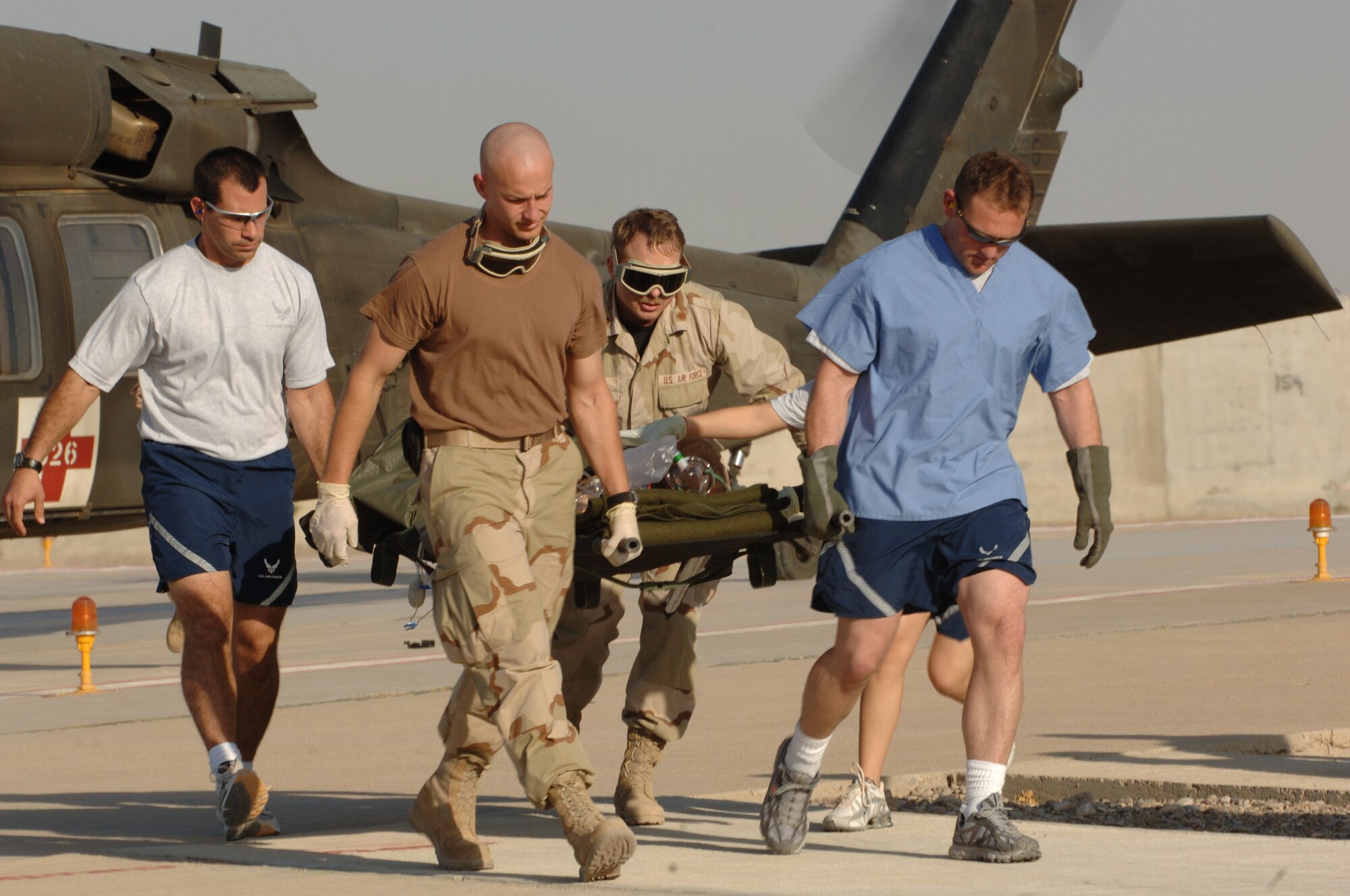 Captain Ian Rybczynsk, Staff Sgt. Mark Frayser, and Majs Layne Bennion and Brandon Smith, 506th Expeditionary Medical Squadron, offload a patient from an Army helecopter for treatment at the emrgency room Sept. 22.  Litter teams consist of public health, administrative, life skills, bioenvironmental, logistics, dental, any other available 506th EMEDS personnel at the time of the incident.