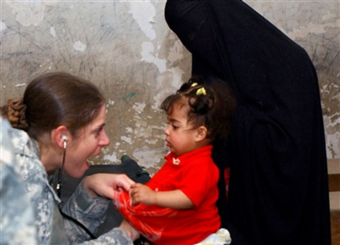 U.S. Army Spc. Carrielynn Spillis (left), a medic with 10th Mountain Division, examines a young Iraqi girl in the town of Rushdi Mulla, south of Baghdad, Oct. 20, 2006.