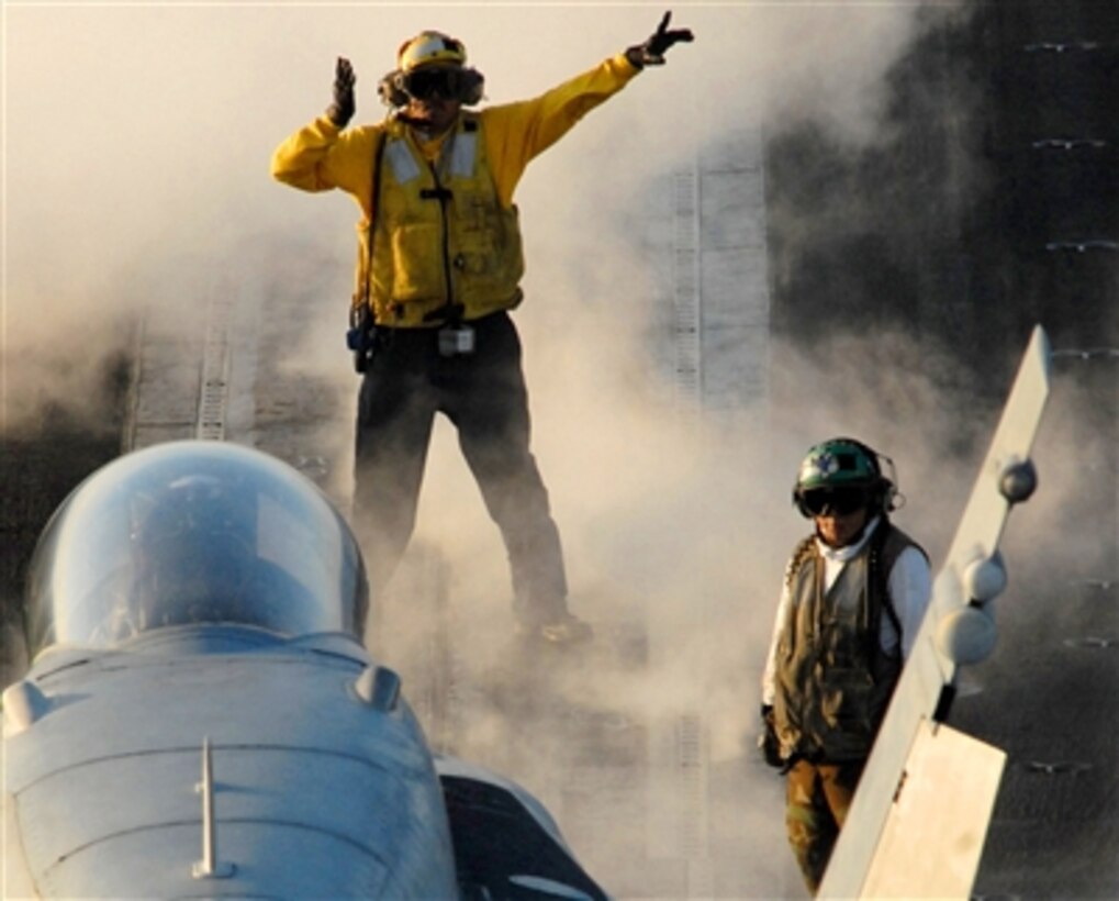 An aviation boatswain's mate (handler) directs an F/A-18 Hornet into its launch position during flight operations on the flight deck aboard the Nimitz-class aircraft carrier USS Ronald Reagan, Oct. 23, 2006. The USS Reagan is currently conducting Fleet Replacement Squadron Carrier Qualifications in the southern California operating area. 