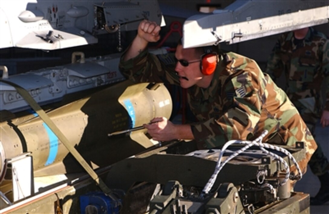 U.S. Air Force Staff Sgt. Andrew Scott, with 523rd Aircraft Maintenance Unit, loads an inert training bomb onto an F-16 Fighting Falcon aircraft during a load crew competition on Cannon Air Force Base, N.M., Oct. 20, 2006.