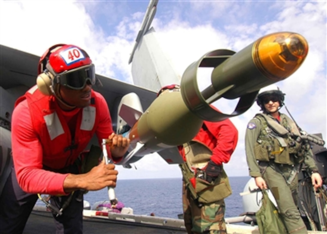 Airman Harold Doe tightens a bolt on a computer-guided inert practice bomb loaded on an F/A-18 Hornet aircraft on the flight deck of the aircraft carrier USS Dwight D. Eisenhower (CVN 69) as the ship operates in the Mediterranean Sea on Oct. 23, 2006. Doe is a Navy aviation ordnanceman attached to Strike Fighter Squadron 131.  