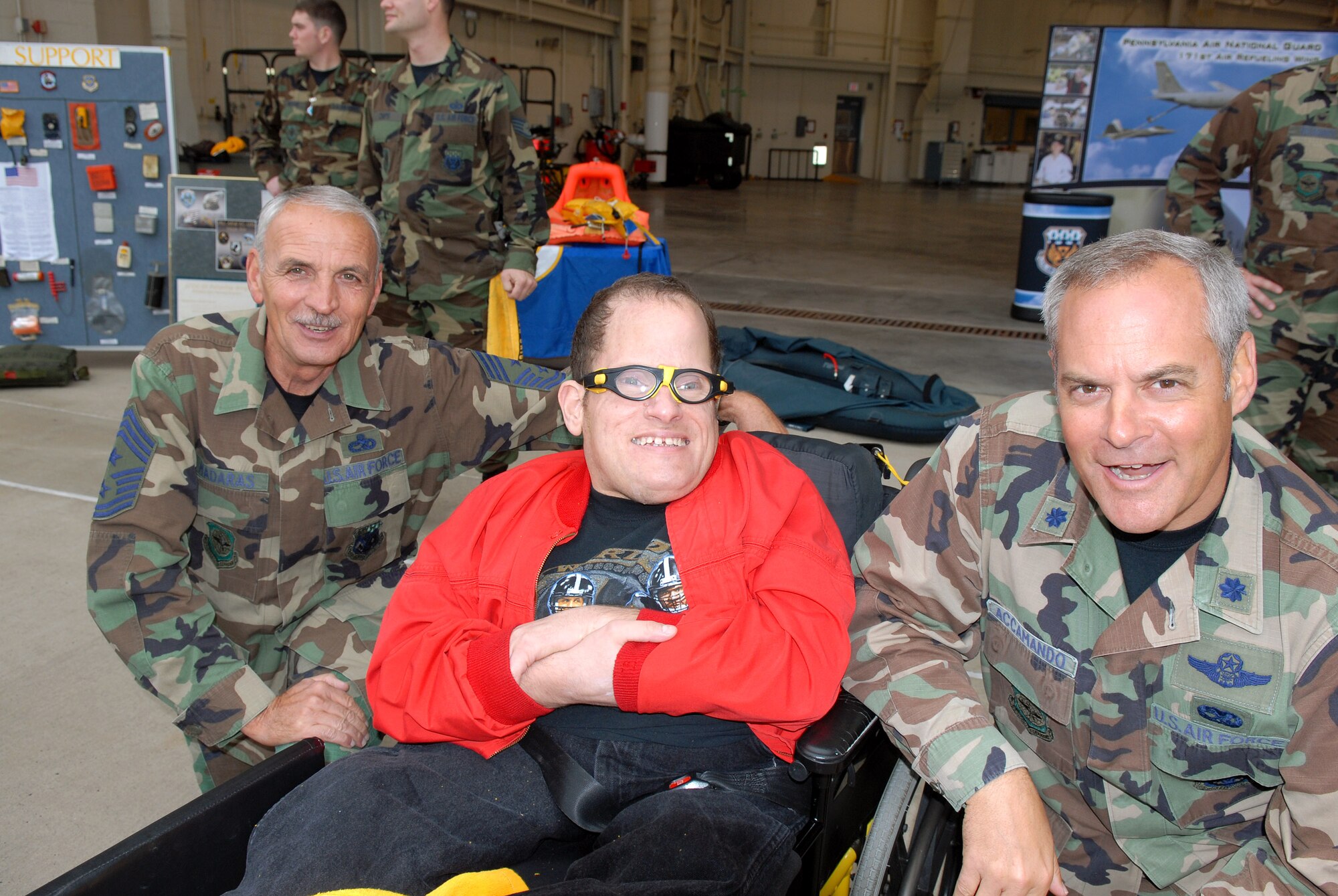 Chief Master Sgt. Paul Madaras and Lt. Col. Don Accamando discuss football with Jimmy Oct. 18.  Jimmy and other residents of nearby Allegheny Valley School along with members of the Pittsburgh Steelers football organization were on hand to help the Airmen of the Pennsylvania Air National Guard's 171st Air Refueling Wing christen the new "Steel City Pride" nose art on the unit's tankers. Chief Madaras and Colonel Accamando are with the 171st.  (U.S. Air Force photo/Master Sgt. Ann Young)