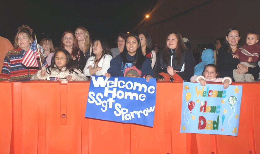 On October 21, 2006 at approximately 11:00 pm family, friends, and supporters, anxiously await the return of troops recently deployed with the 317th Airlift Group. They stand in the cold air holding signs and flashing smiles to welcome back our troops.USAF Photo By: A1C Domonique Simmons