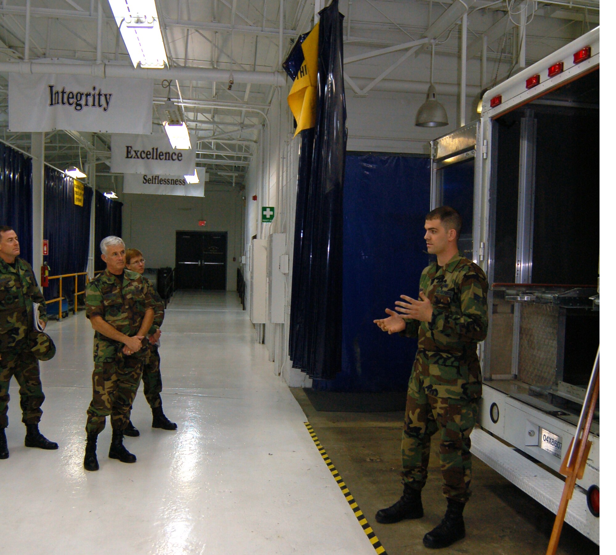 Airman 1st Class William Werner (right), 436th Maintenance Squadron aircraft metals technologist, briefs Col. William Wootton, Air Mobility Command Maintenance Division chief and Daedalian Award Team chief, and the rest of his team at the “Monster Garage” in Building 721 here Monday about various modifications to vehicles at Dover to increase load capacity and improve loading systems. Dover is one of three AMC bases in the running for the Maj. Gen. Clements McMullen Memorial Weapons System Maintenance Trophy. The award is presented annually to a U.S. Air Force unit at the wing level for having the best weapon system maintenance record for the preceding calendar year. This is the first time Dover AFB has been a finalist for the award since 1986.  The AMC Daedalian Award Team arrived here Sunday for a two-day tour of various facilities to observe the integration of maintenance with the total wing mission. The team’s itinerary included the “Monster Garage,” Isochronal Inspection Dock, Air Force Smart Operations 21 classroom, Combined Avionics System Trainer, and all other maintenance related facilities. (U.S. Air Force photo/Staff Sgt. James Wilkinson)
