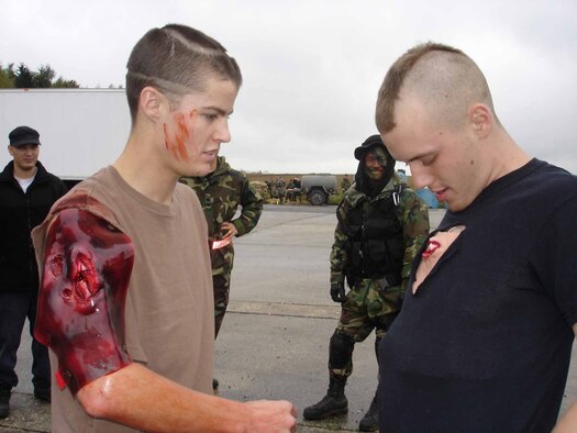Opposition forces help each other with moulage makeup, readying for a bus bomb scenario that drives course attendees to practice self-aid buddy care on Bitburg Air Base Monday. Photo by Capt. Erin Dorrance