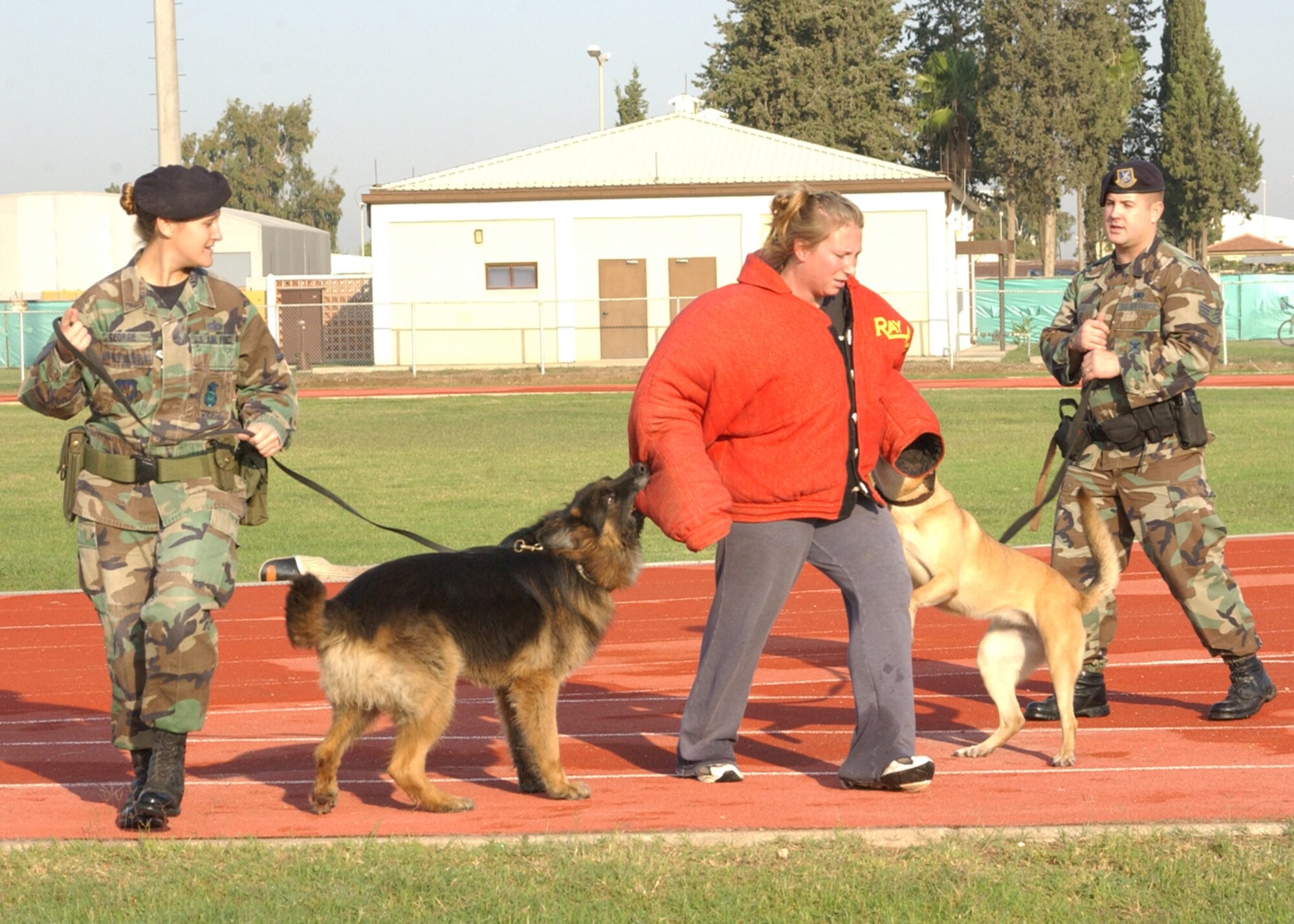 Staff Sgts. Jessica George, far left, and Kenneth Davis, far right, both 39th Security Forces Squadron military working dog handlers, demonstrate what happens to people when they take drugs to Incirlik American School Students after they marched in the Red Ribbon parade Oct. 26. (U.S. Air Force photo by Airman 1st Class Tiffany Coulburn)