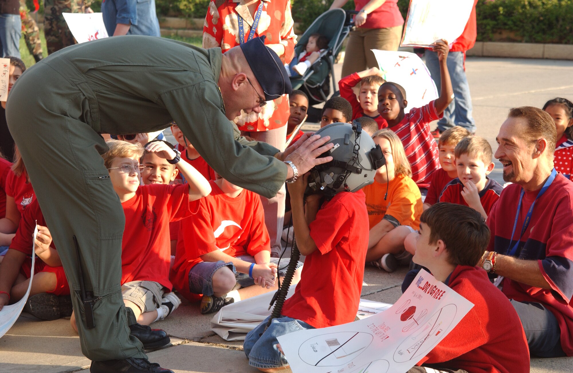 Colonel Murrell "Tip" Stinnette, 39th Air Base Wing commander, lets Incirlik American School elementary students try on a helmet outside of the commissary during their break at for Red Ribbon parade, Oct. 26.  (U.S. Air Force photo by Airman Kelly LeGuillon)   