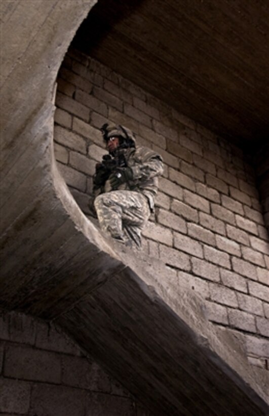 U.S. Army Sgt. 1st Class David Hall climbs a flight of stairs during a search for weapons caches near the village of al Buwatir, Iraq, on Oct. 14, 2006.  Hall is a platoon leader from Alpha Company, 2nd Battalion, 35th Infantry Regiment, 25th Infantry Division.  