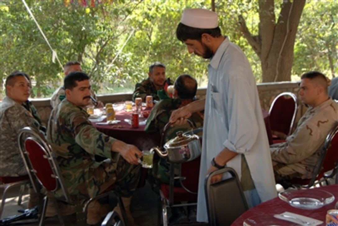 An Afghan local pours tea for an Afghan National Army soldier during a celebration marking the end of Ramadan. The event was hosted by the Jalalabad Provincial Reconstruction Team for provincial governors in Jalalabad, Afghanistan, Oct. 24, 2006. 